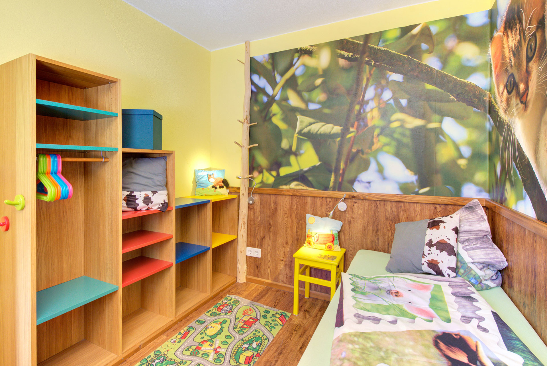 kinderzimmer mit regal stuhl und einzelbett in der Ferienwohnung