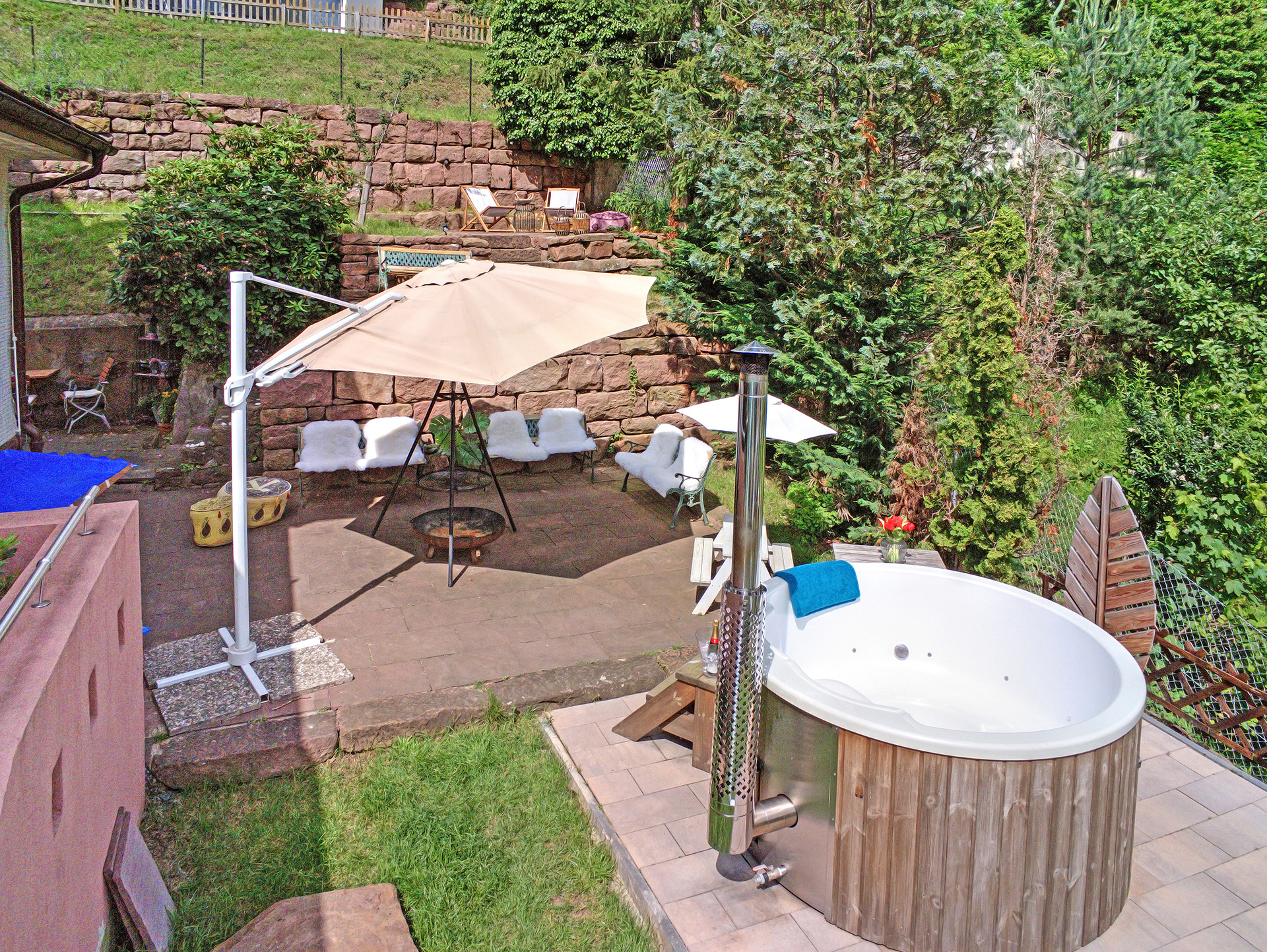 Garten des Schwarzwaldhaus mit leerem Outdoor-Whirlpool und gemütlicher Feuerstelle, fotografiert aus der Luft