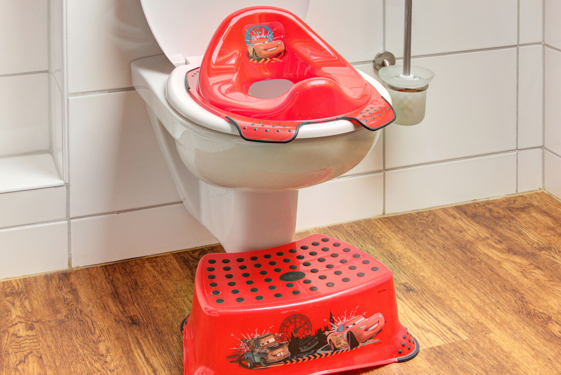 rote hochsteighilfe und toilettensitu für kinder im badezimmer im ferienhaus