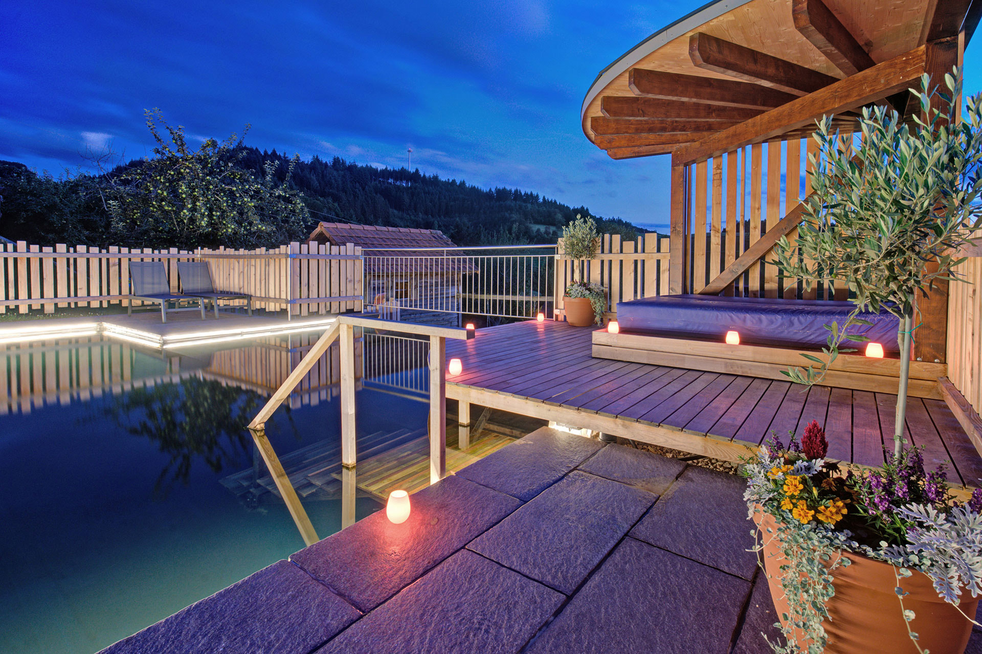 Naturpool bei blauer Abendstimmung mit LED-Lichtern