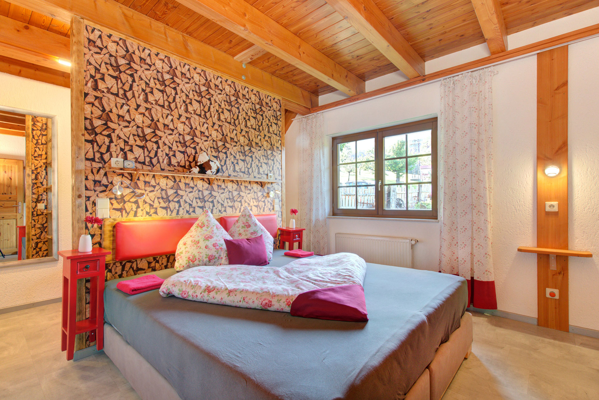 grosses doppelzimmer mit bettdecke in herzform und gartenfenster im ferienhaus