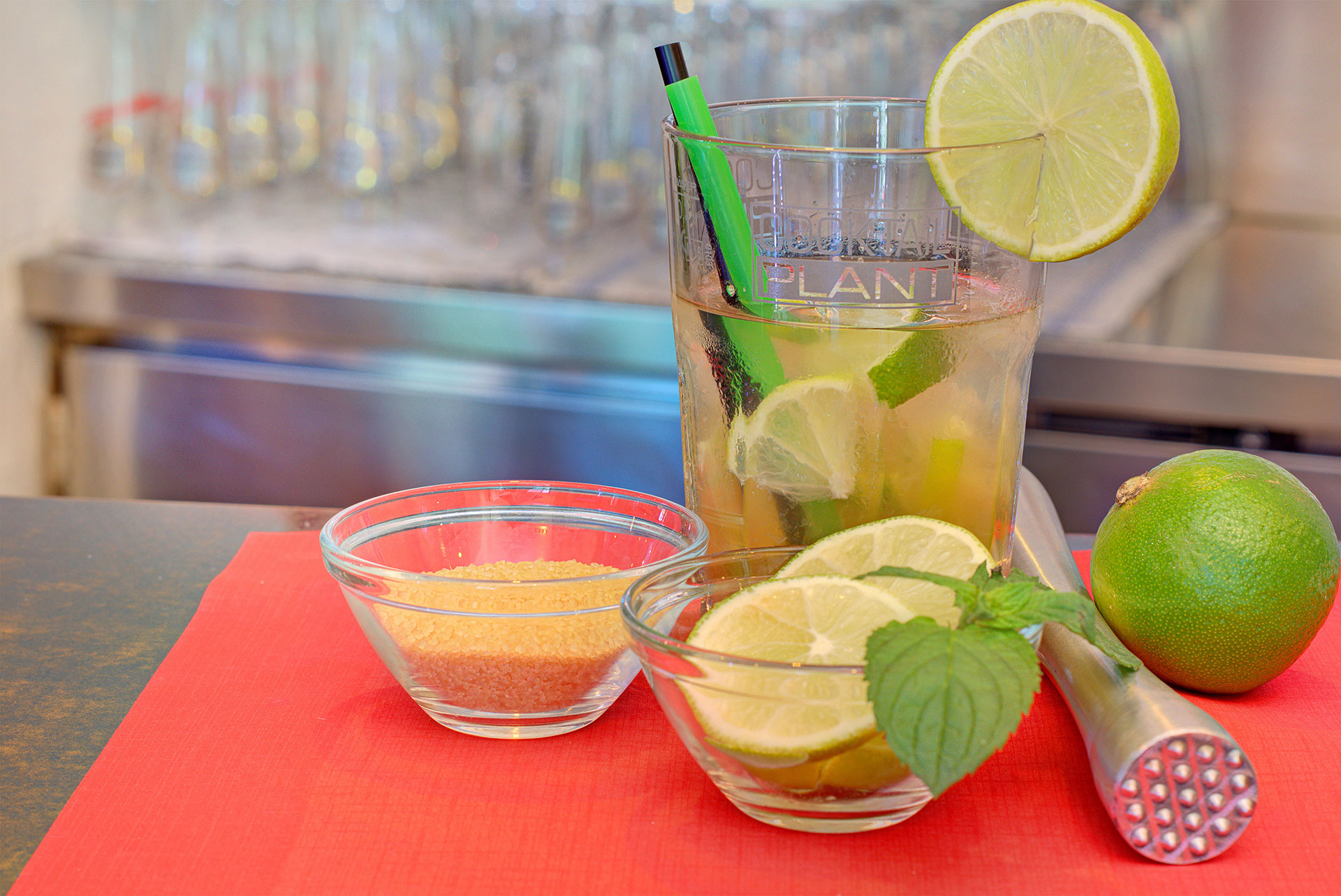 kneipe foto theke caipirinha mit roehrchen sowie zucker und limonen extra in schaelchen hintergund silberfarbene spuele detailbild