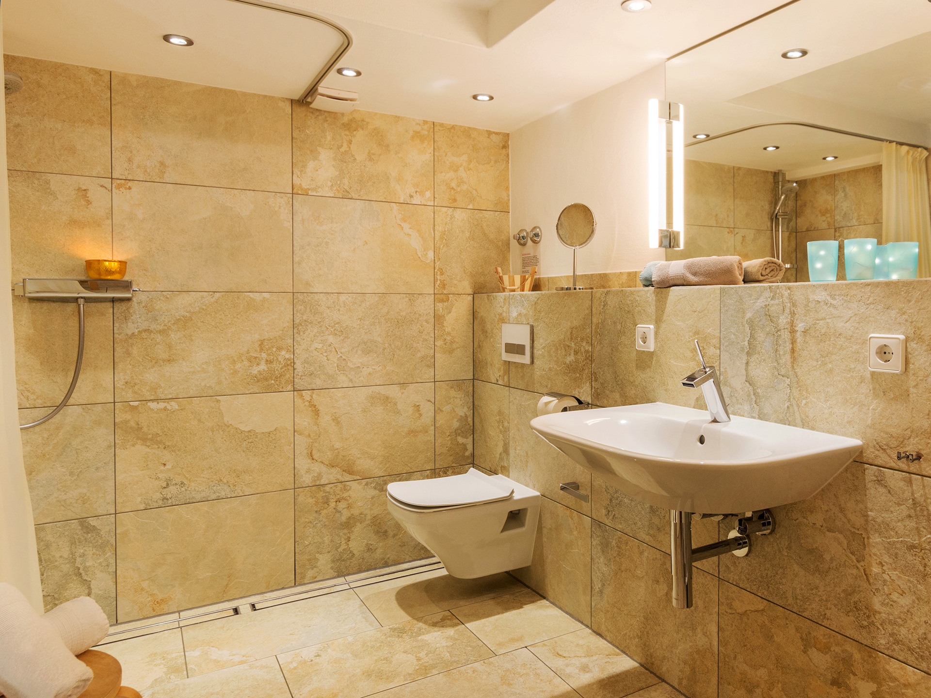 grosszügiges barrierefreies badezimmer mitwaschbecken und toilette steinfliesen in ferienwohnung