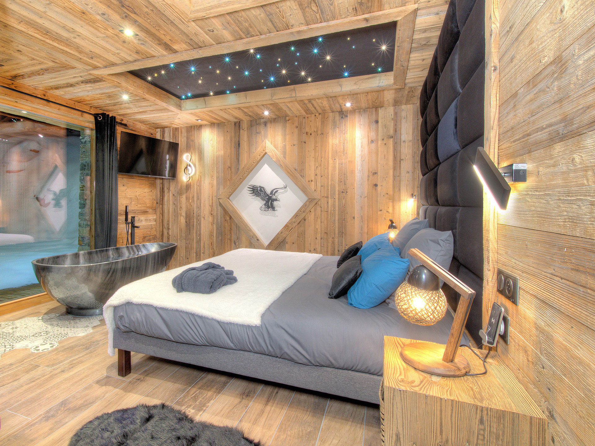 Naturholzschlafzimmer am Abend mit Sternenhimmel Badewanne und Blick zum Abendfenster
