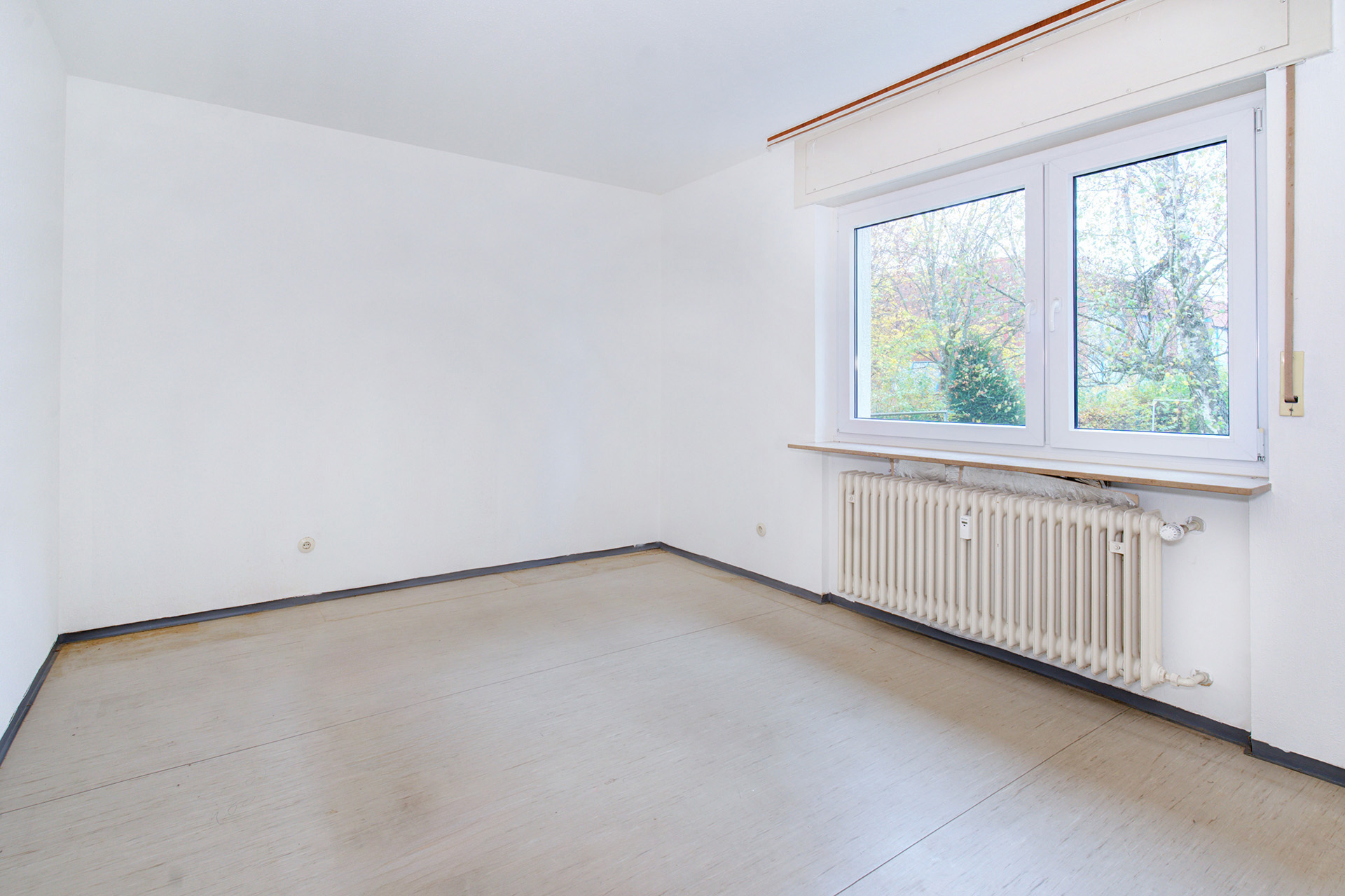 Kleineres leeres Schlafzimmer mit Fenster zum Garten - immobilienfoto für virtual staging