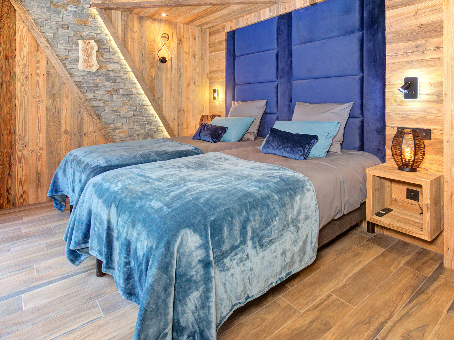 Modernes Chalet-Schlafzimmer mit Boxspringbett und türkisfarbener Überdecke