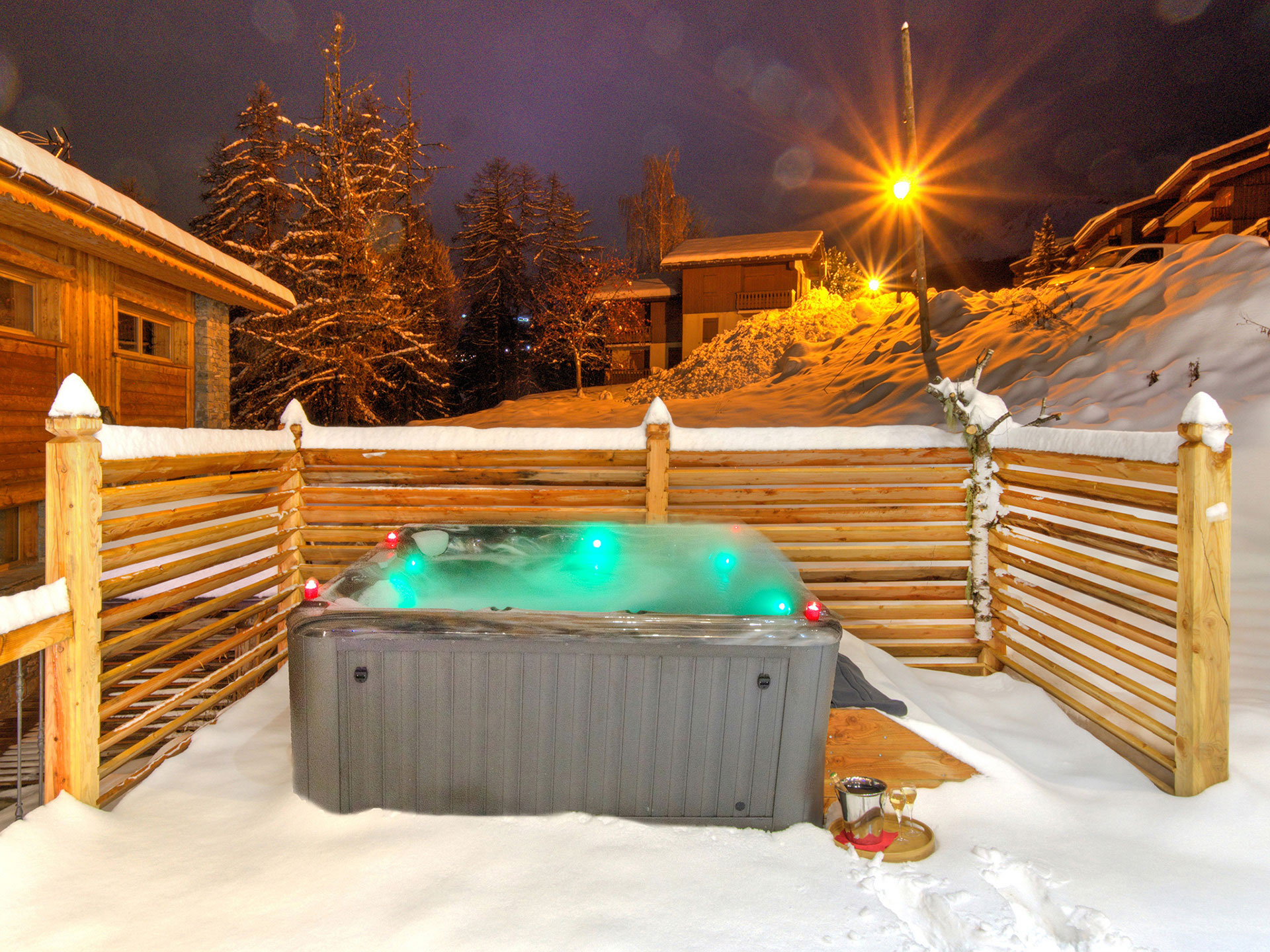 Grün leuchtender Jacuzzi in der Nacht mit Straßenleuchtenstern