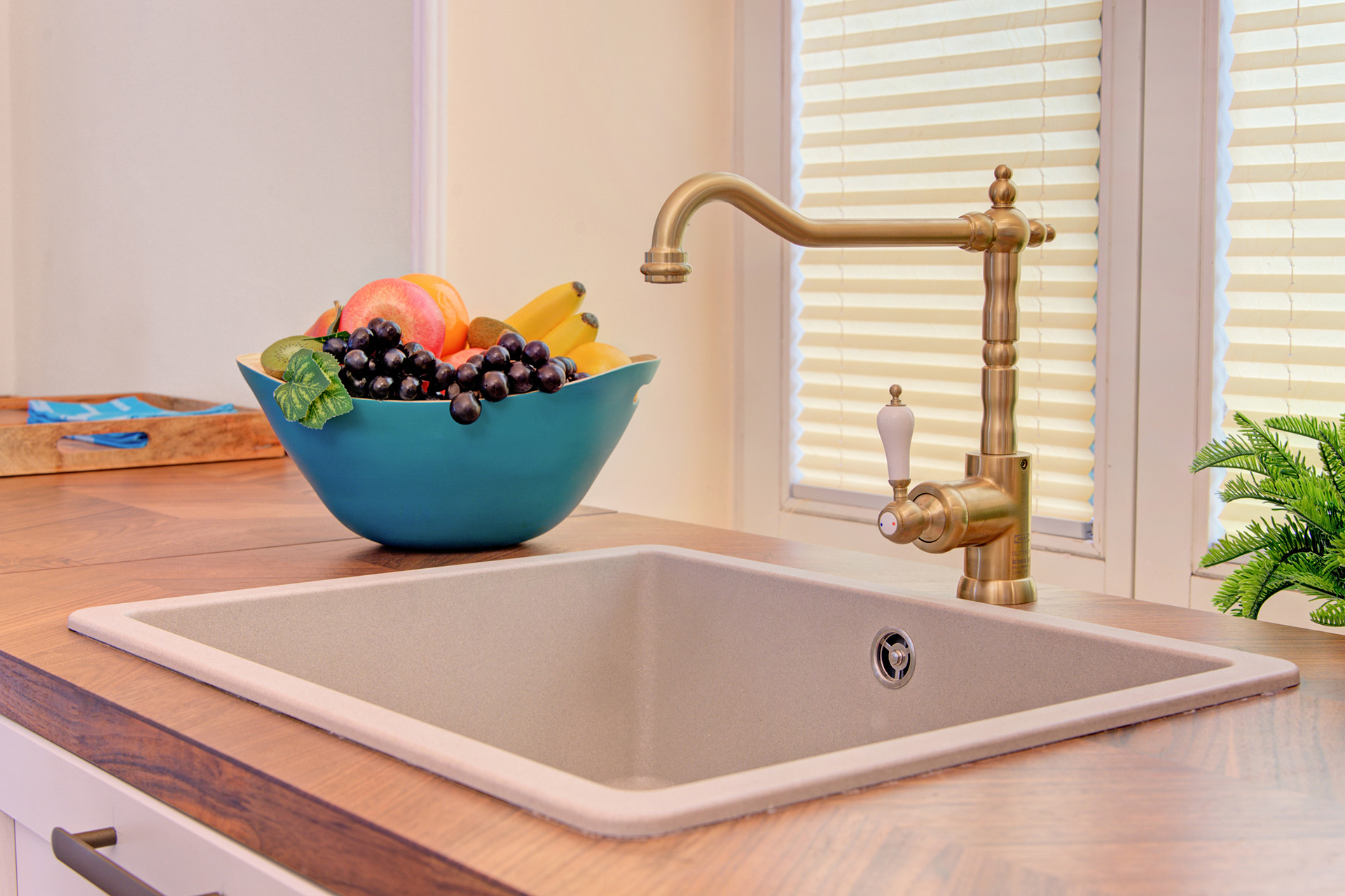 spülbecken mit antikem wasserhahn und obstkorb