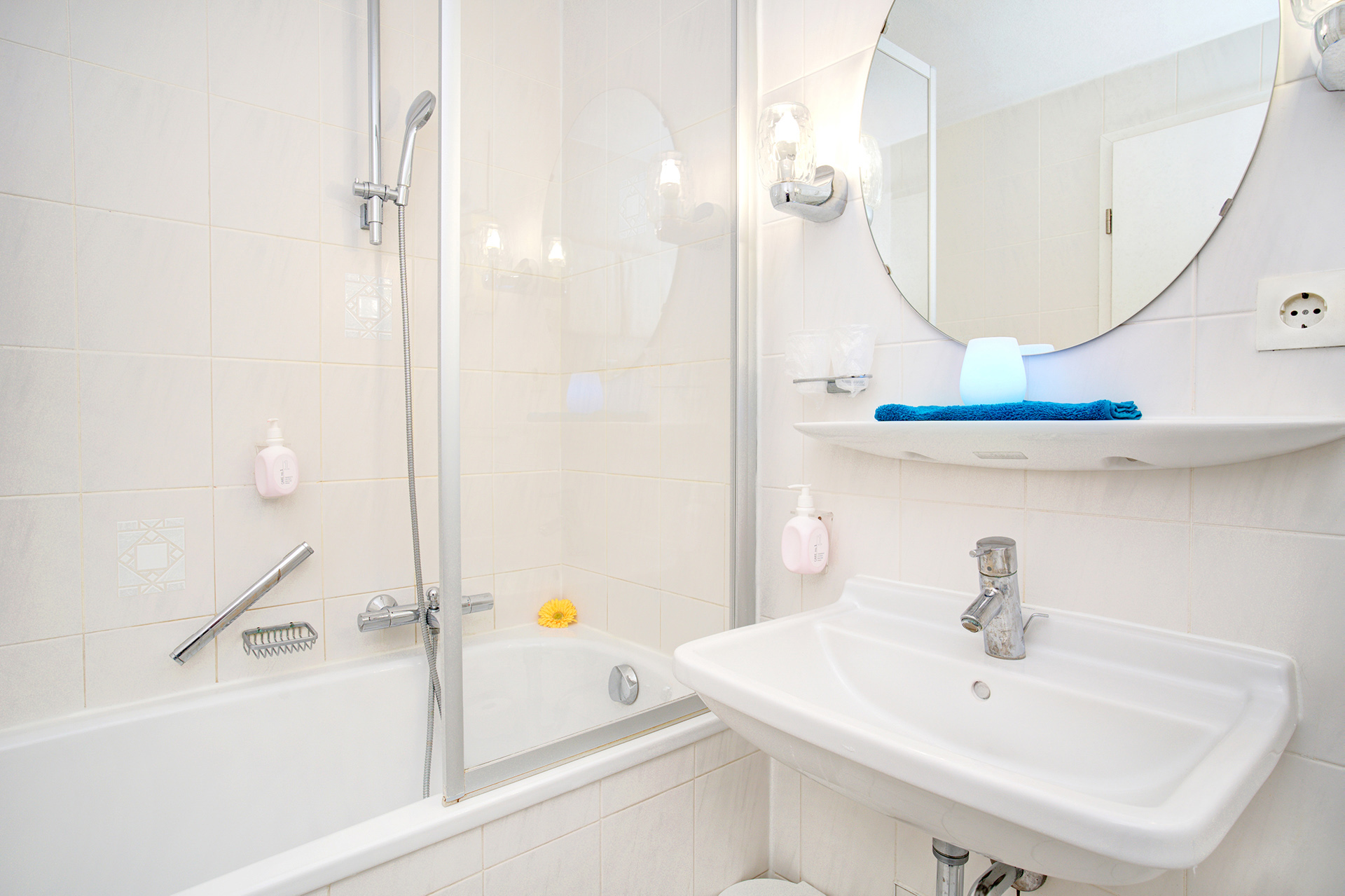 badezimmer mit badewanne und licht auf ablage in türkis