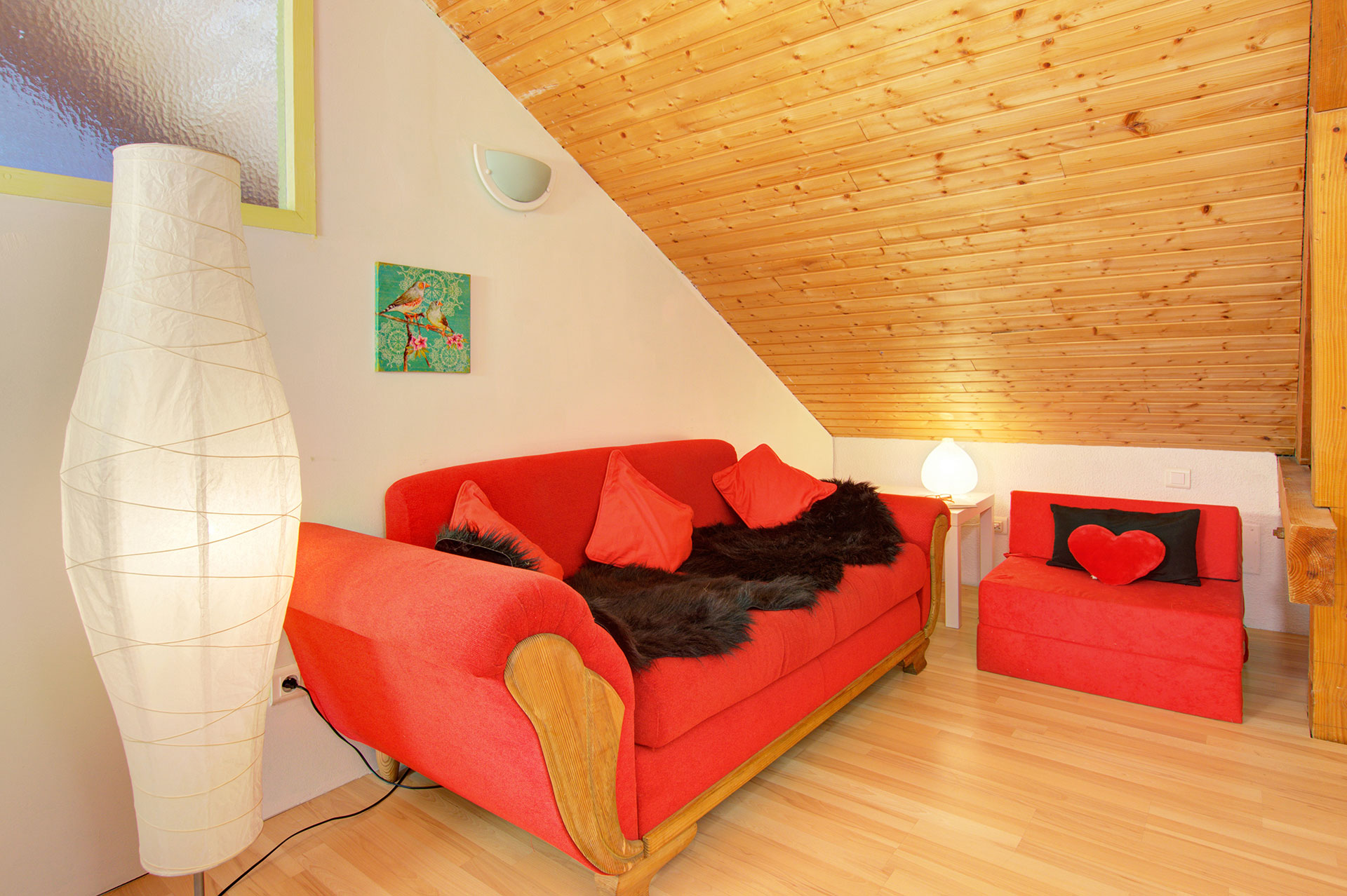 ferienhaus foto rotes sofa mit brennder lampe und schwarzem fell