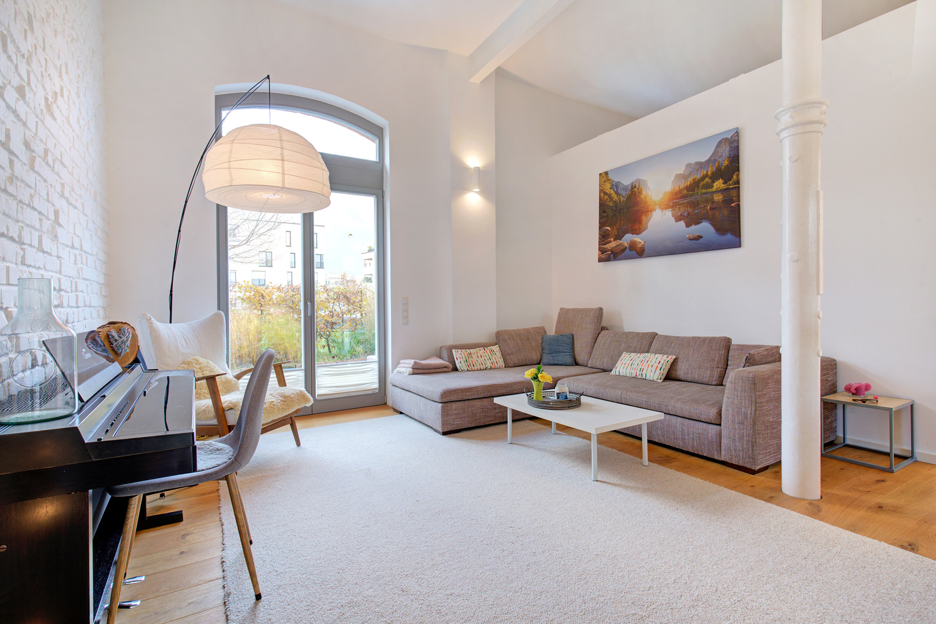 Stilvoll eingerichteter Wohnraum mit Sofa und Klavier im Verkaufsobjekt