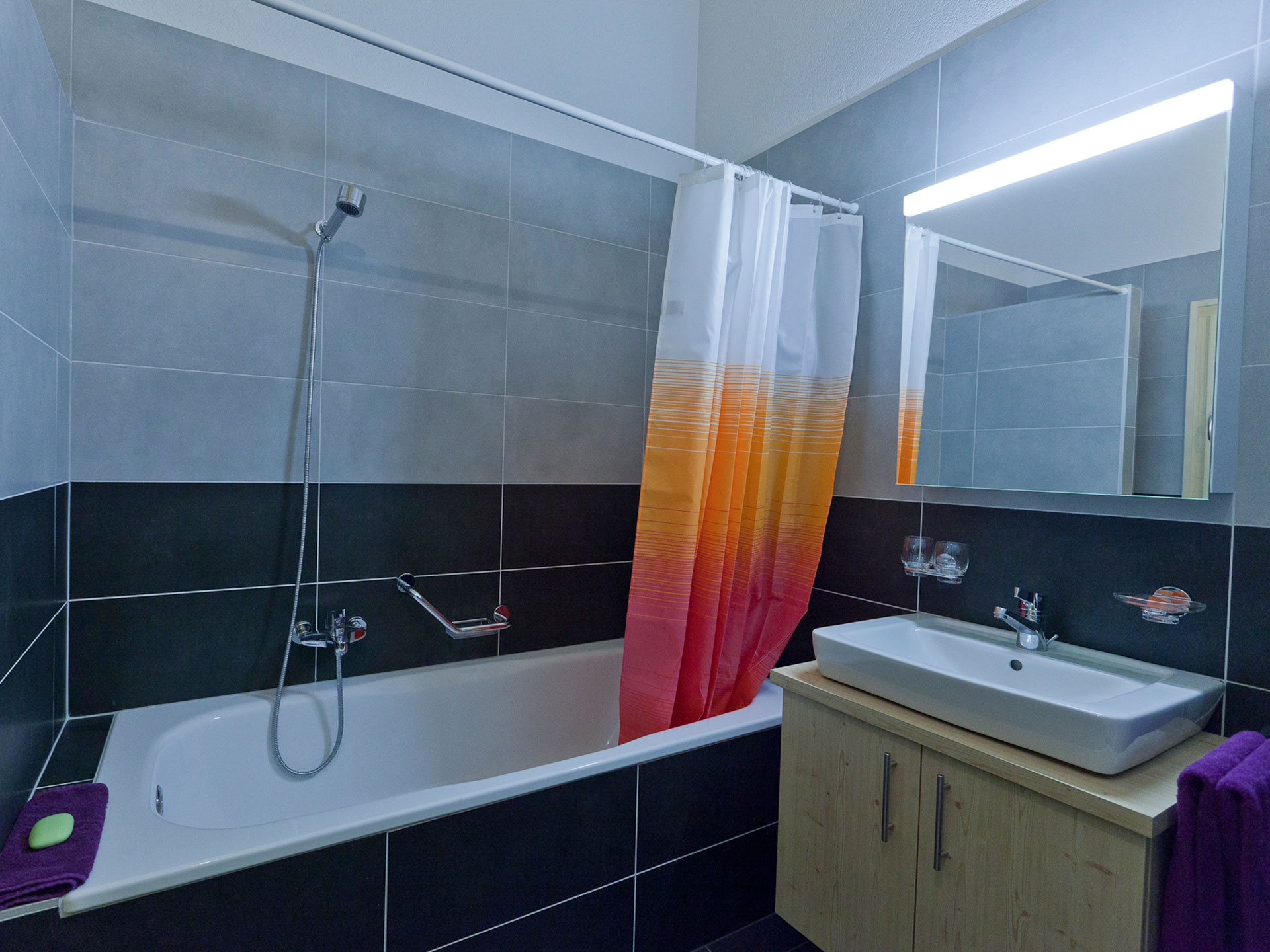 Stilvolles etwas verzerrtes Badezimmer mit Badewanne, retro Duschvorhang, schwarze und weise Kacheln - vorher