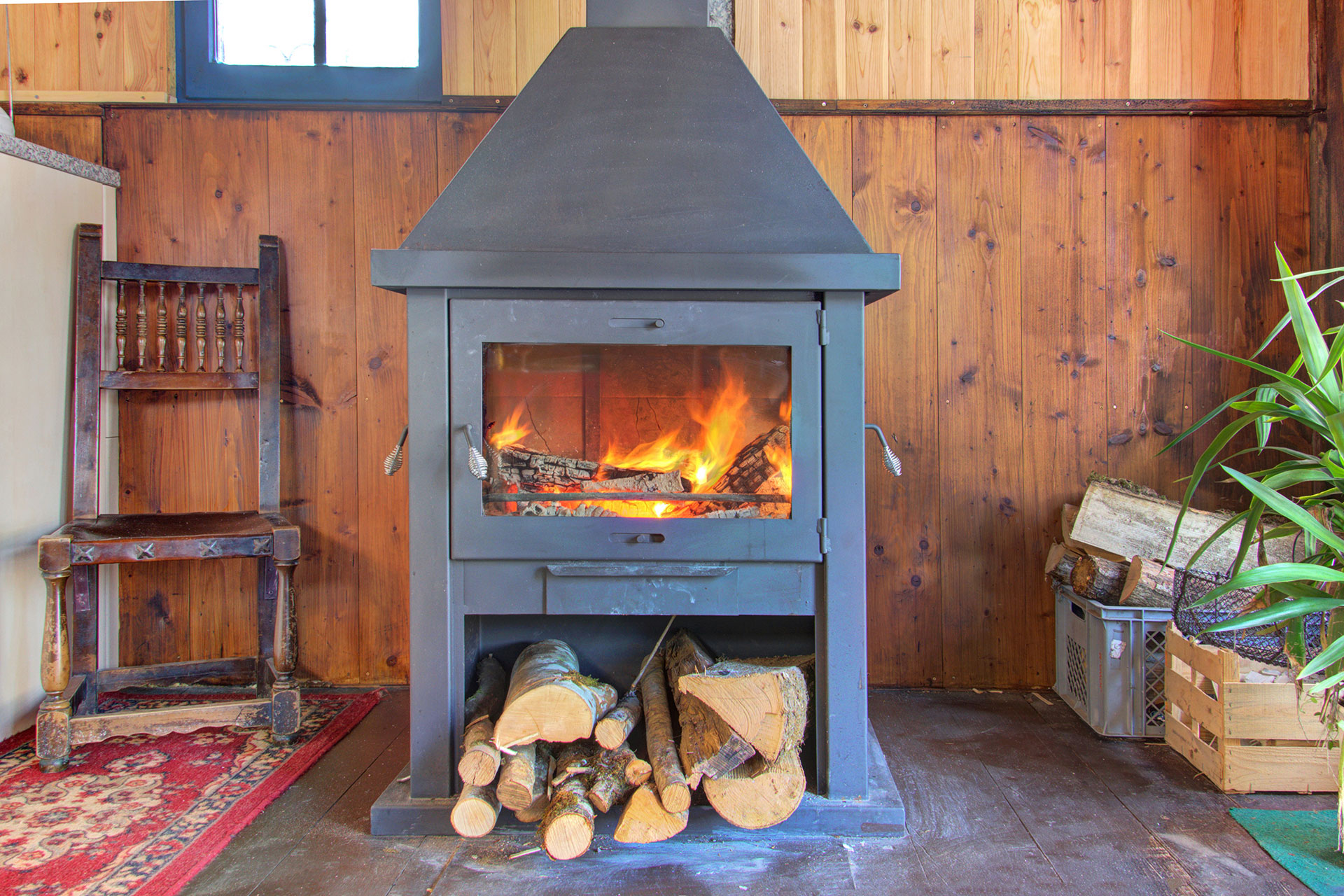 ferienhaus foto brennder Kamin mit holzscheiten davor