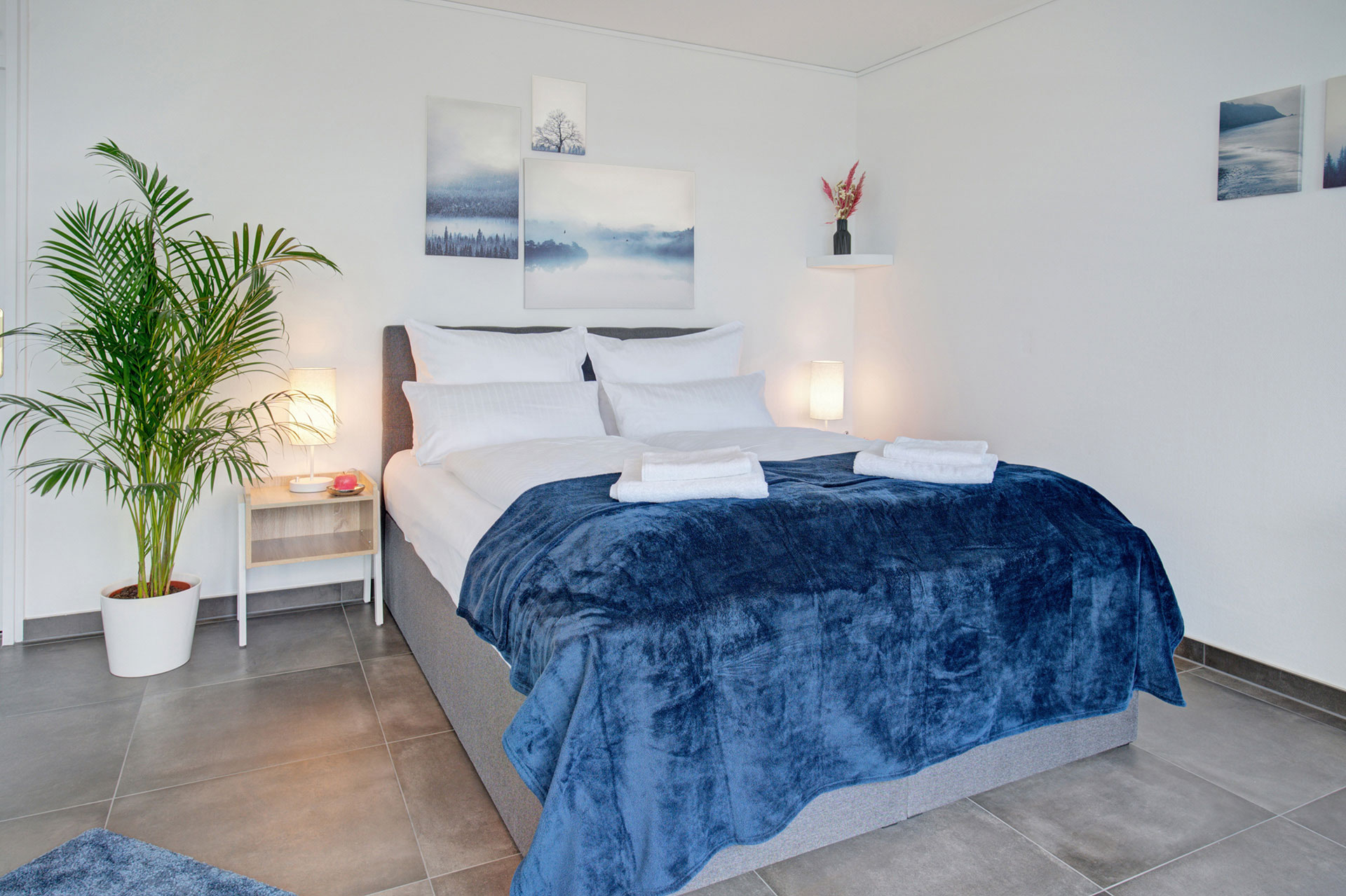 schlafzimmer in blau weis mit leuchten auf nachhtischen in penthouse