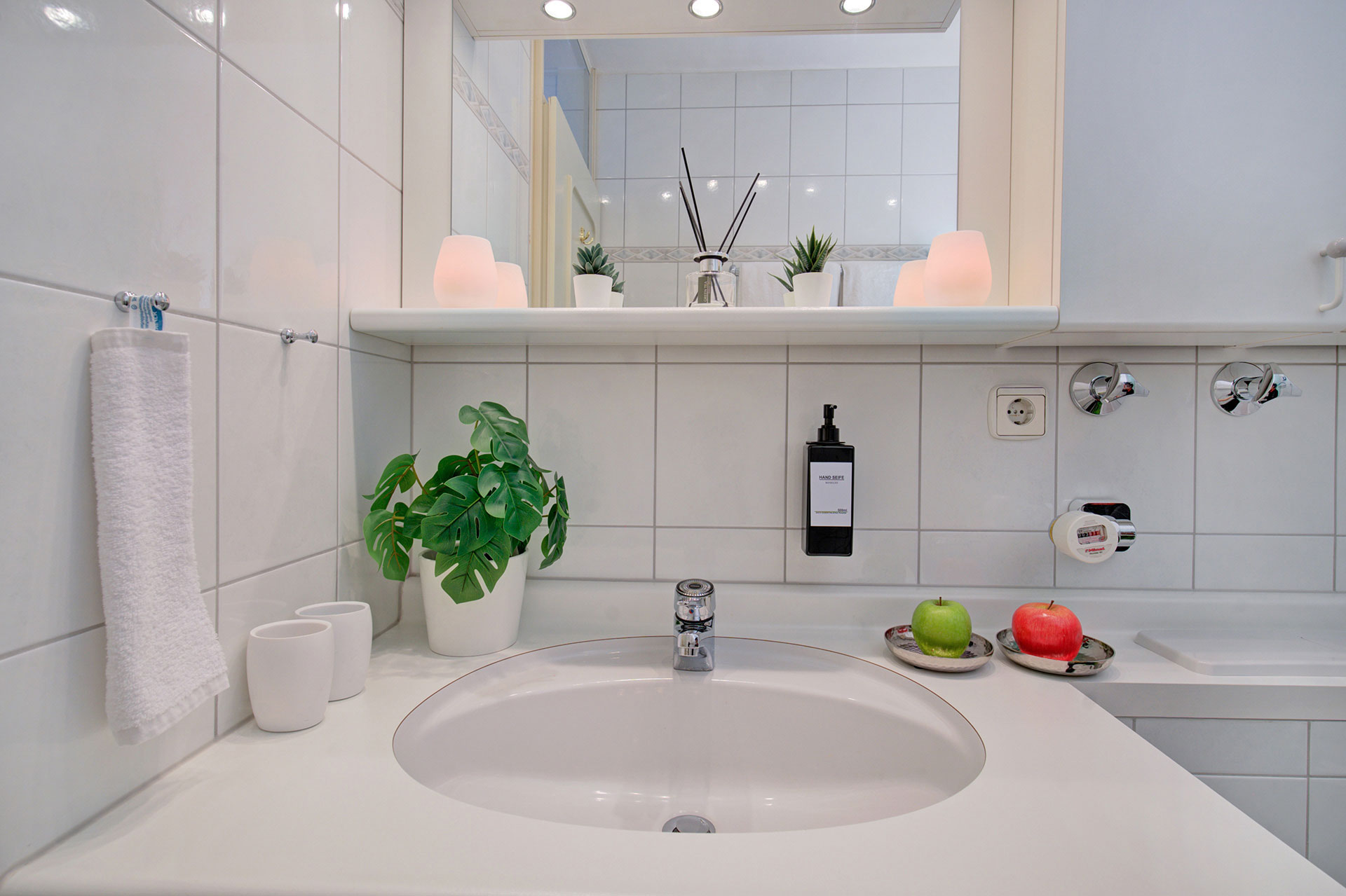 nahaufnahme weises waschbecken mit spiegel und accessoires