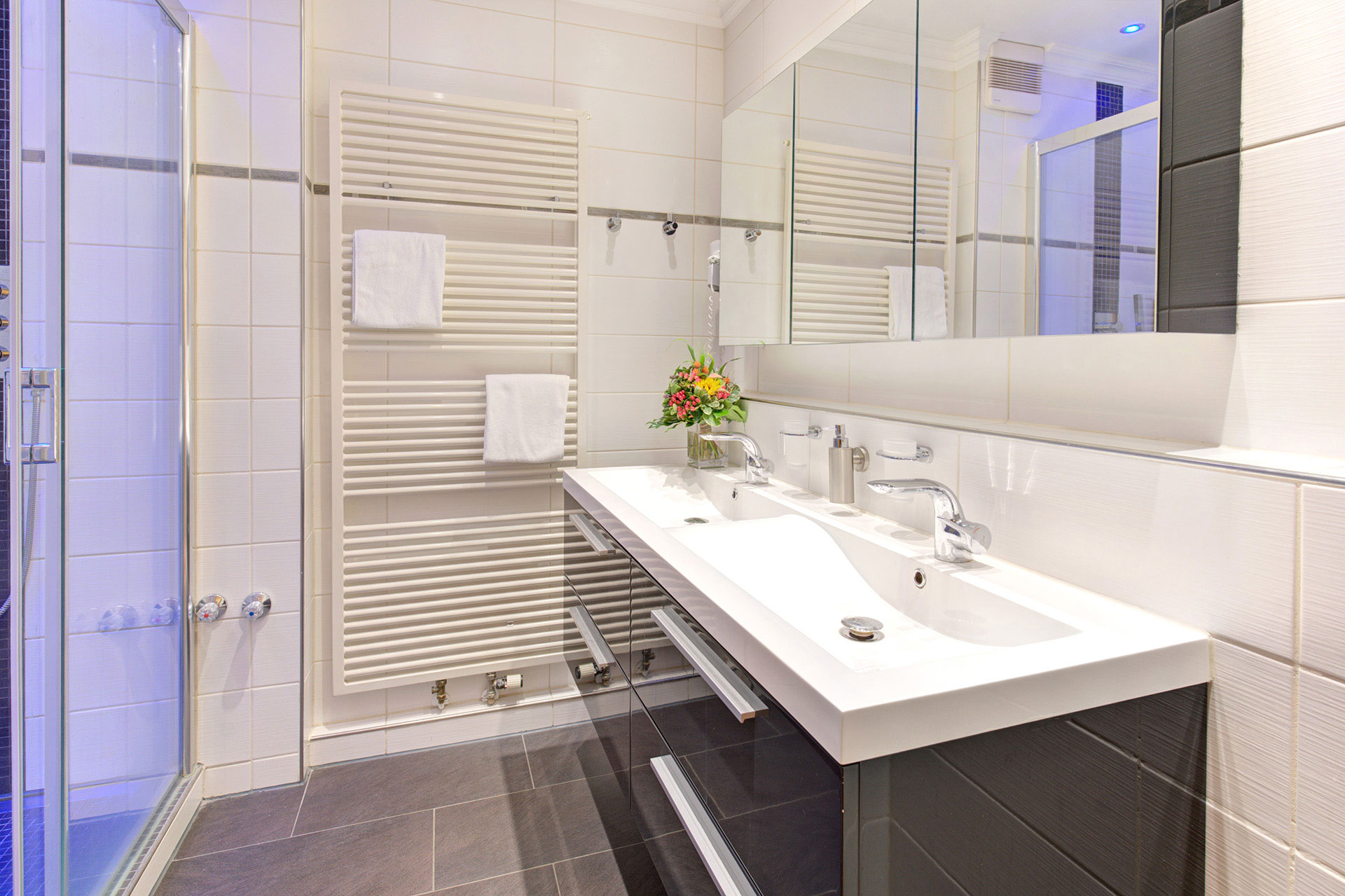 badezimmer weis braun mit blumenbouquet in hotel