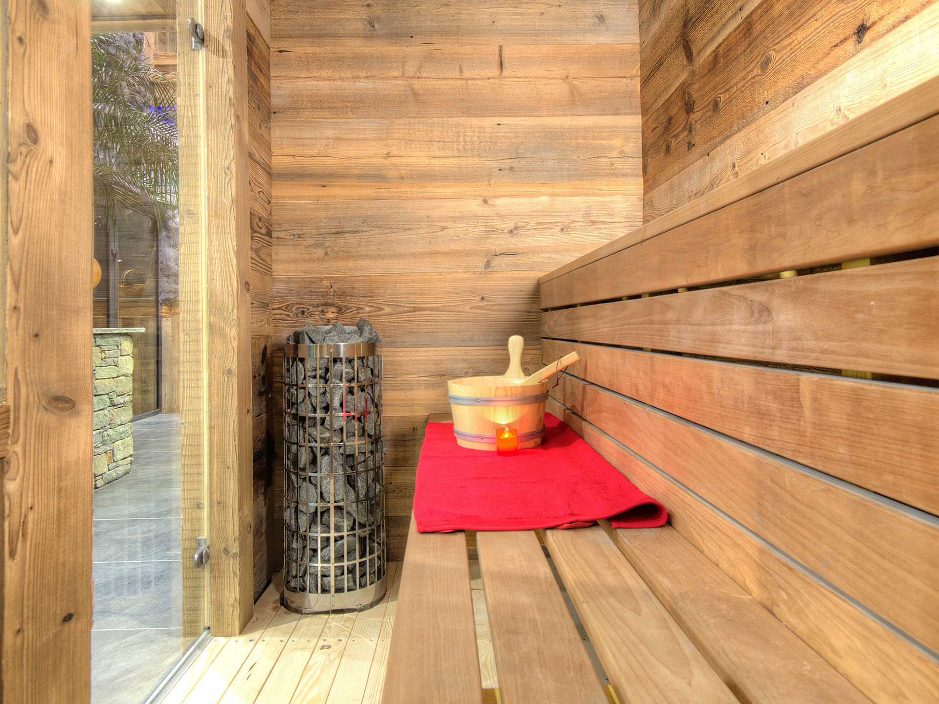 Helle Sauna mit rotem Handtuch Ofen und Saunakübel