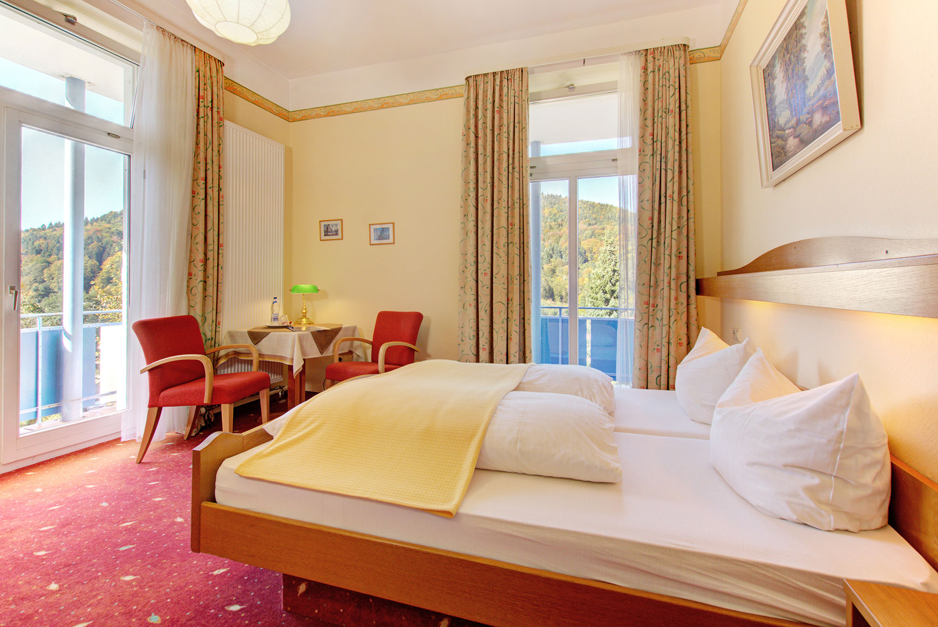 hotelfoto doppelzimmer mit roter sitzecke und blick auf schwarzwald