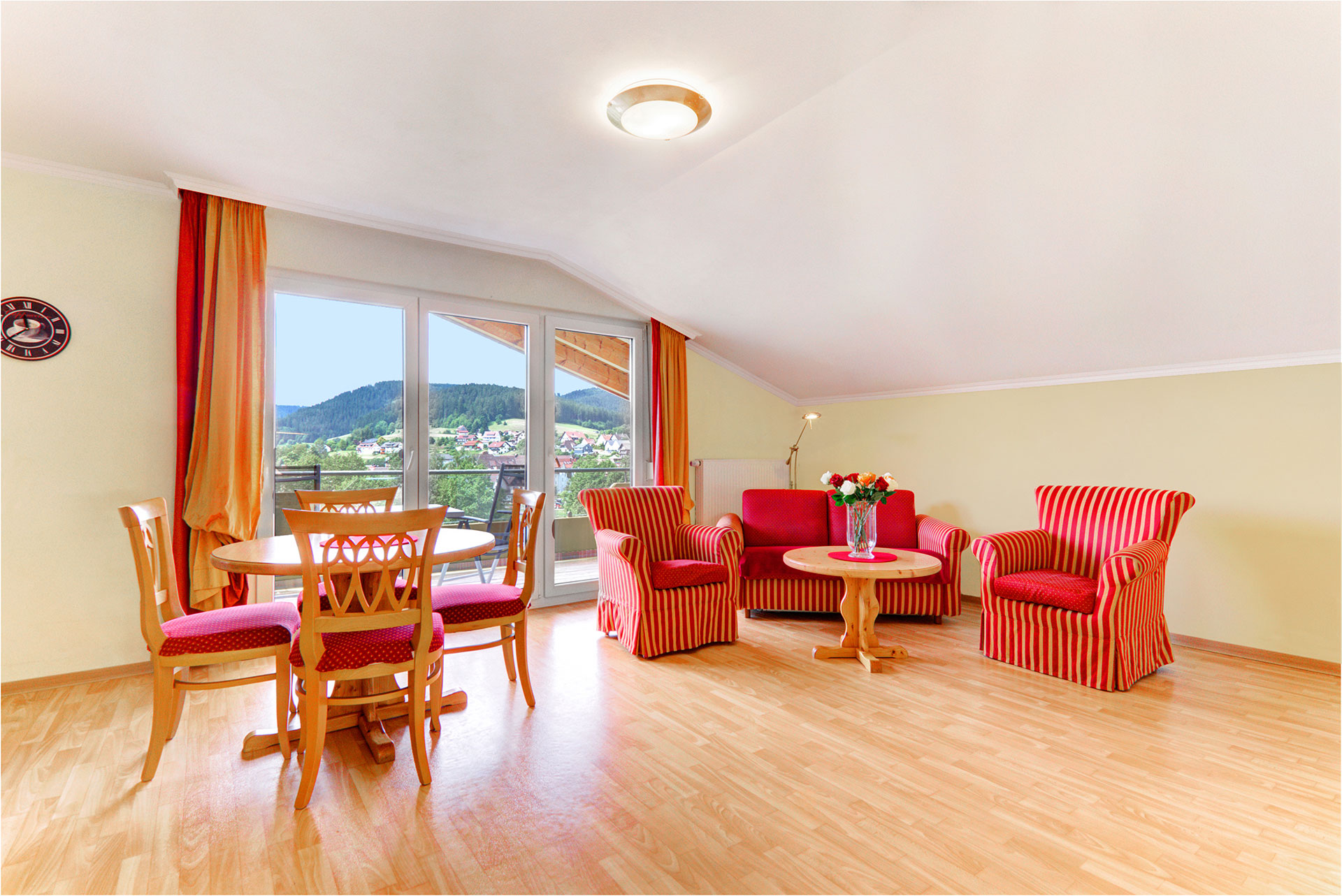 foto ferienwohnung rotes grosses sofa und rote esstischgarnitur mit panoramablick auf landschaft