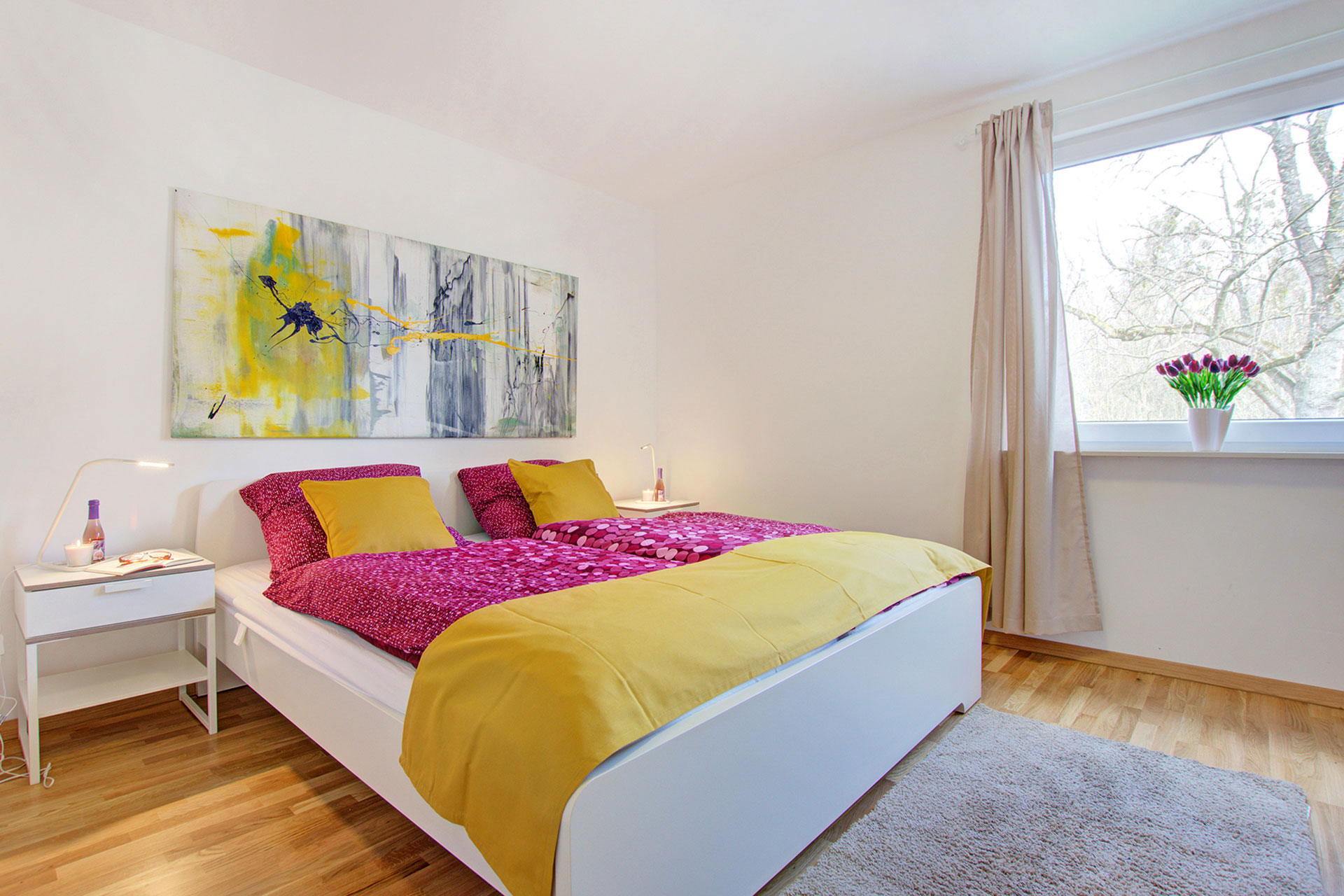 doppelzimmer mit ocker bettläufer und lila bettwäsche in apartment