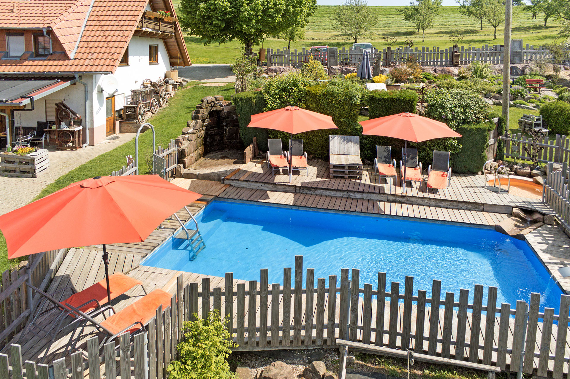 naturpool aus vogelperspektive mit liegebereich und garten am ferienhaus