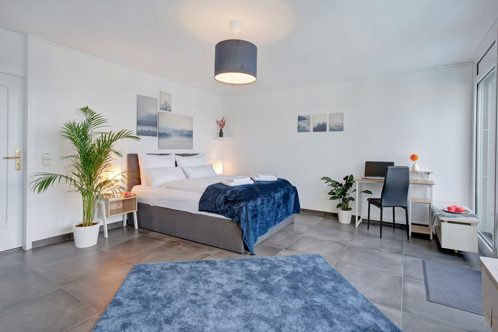 modernes schlafzimmer in blauweis mit Zugang zum balkon mit whirlpool und panoramablick