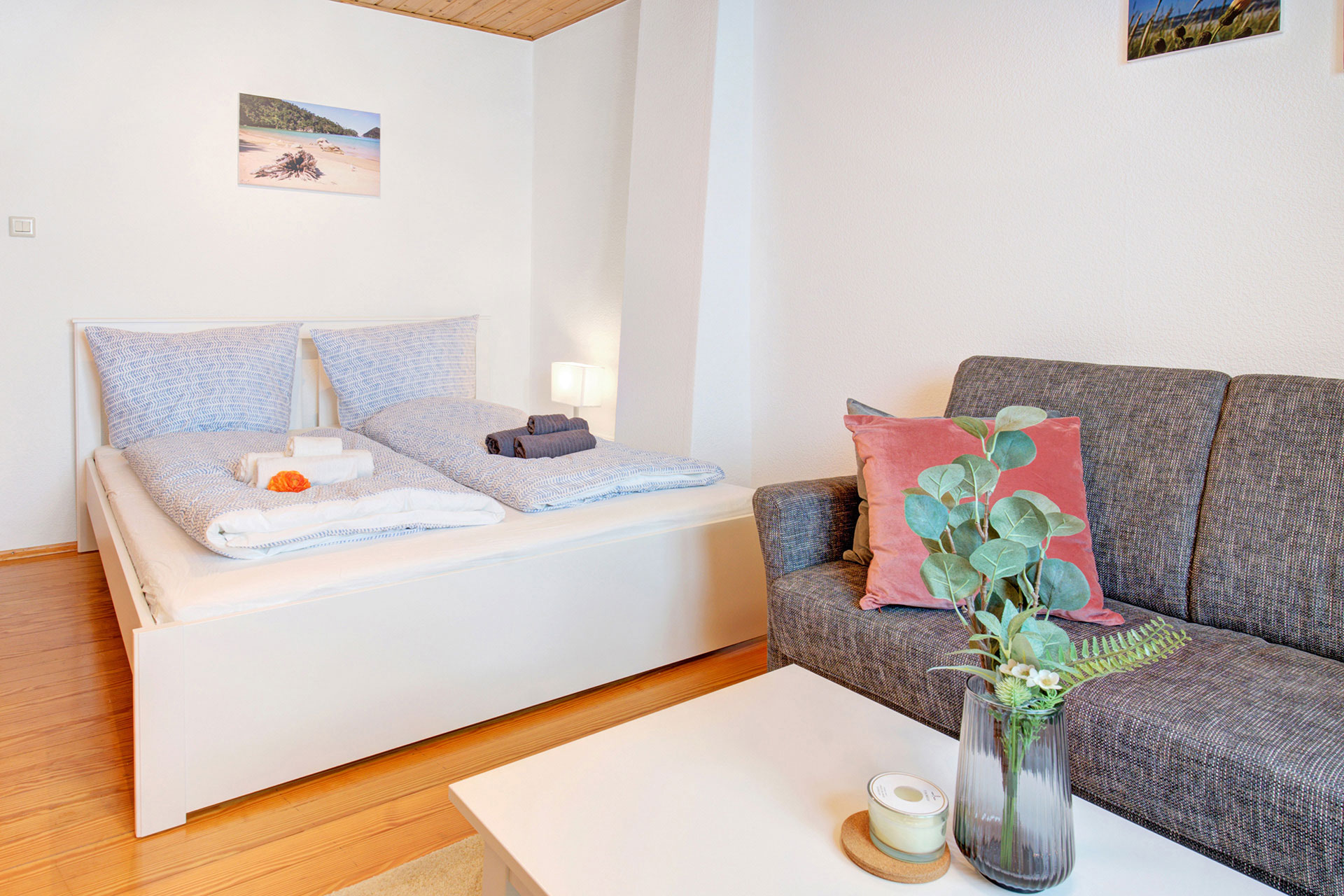 schlafzimmer mit sofa und eucalyptus auf tisch von ferienhaus professionell fotografiert