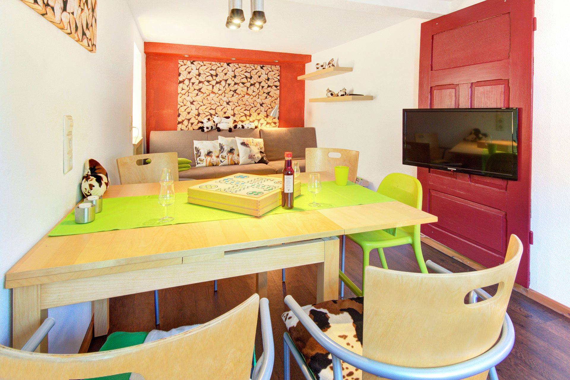 wohnzimmertisch mit spielen und blick auf sofa mit tv der Ferienwohnung