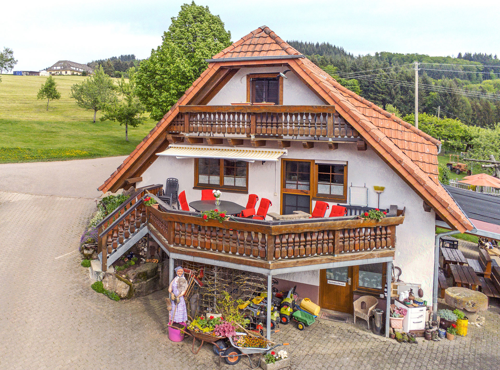 ferienhaus mit terrasse sitzgruppe und roten geranien - vom luftbild fotograf