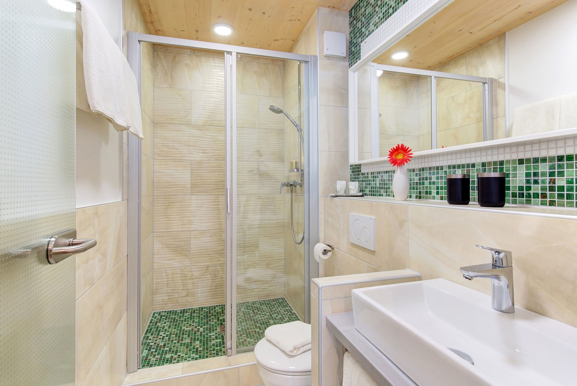 badezimmer mit dusche kleine vase orangene gerbara in hotel
