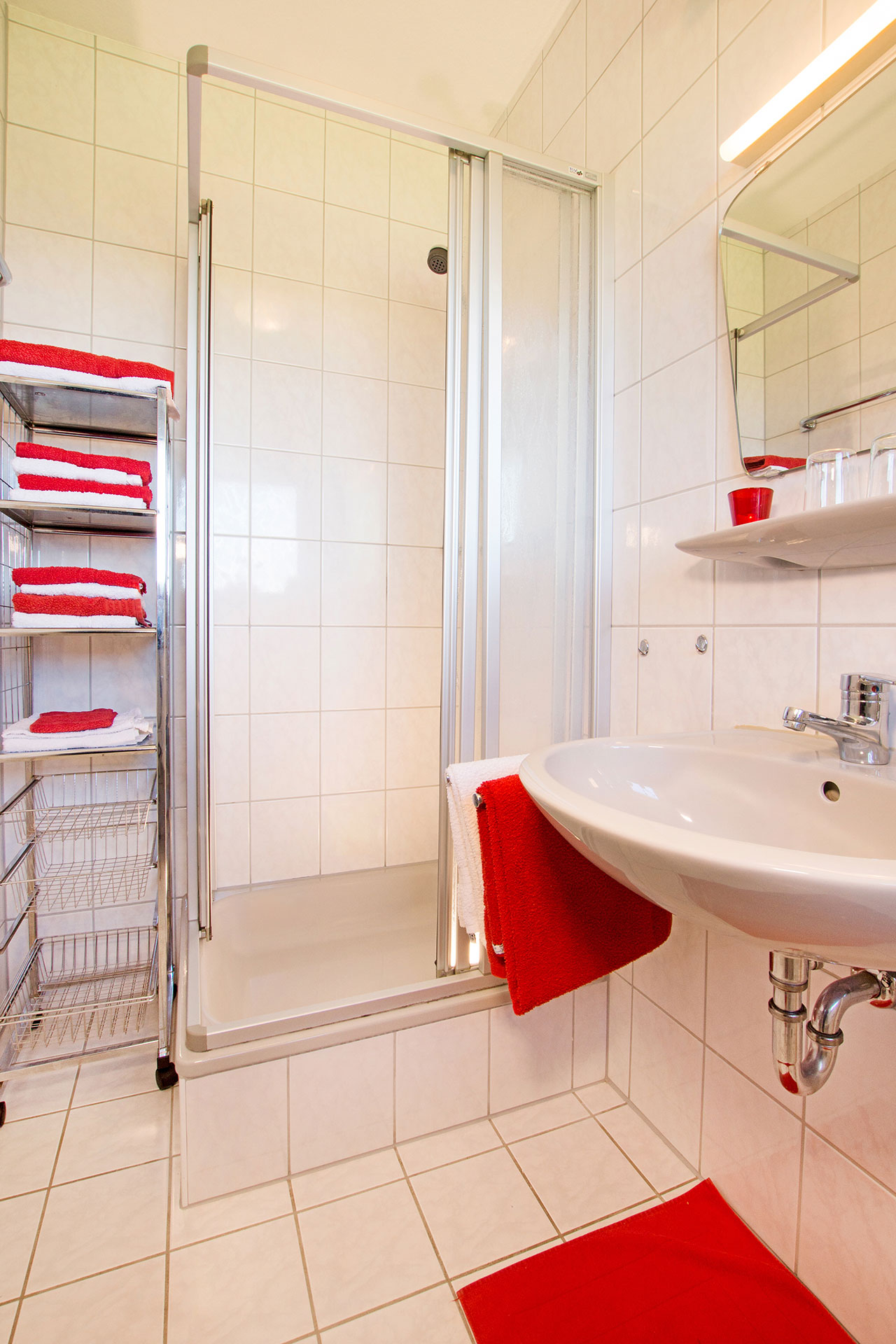 foto ferienwohnung nachher badezimmer hell freundlich mit roten handtüchern