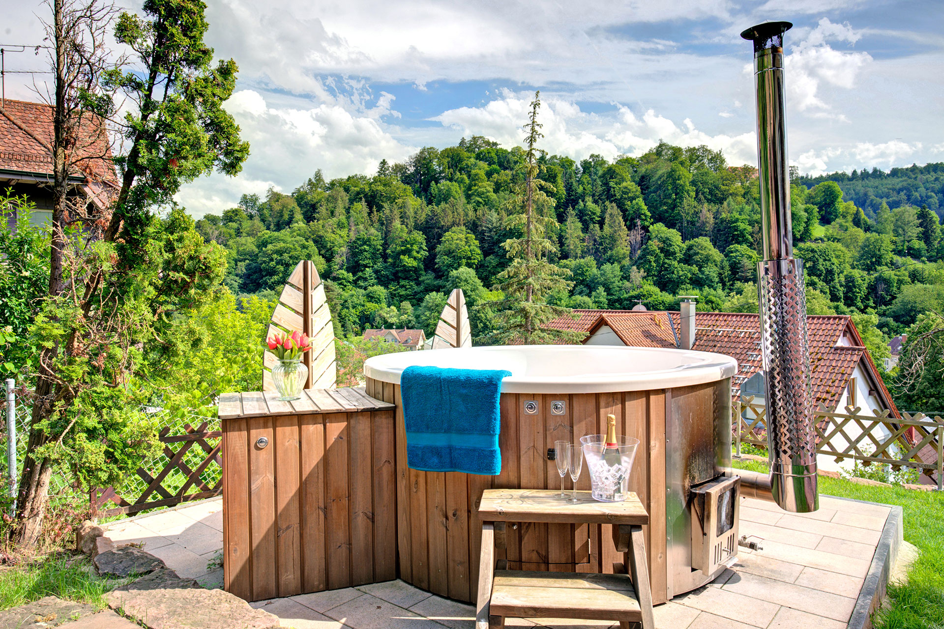Außenbereich eines Ferienhauses: Hot Tub ohne Wasser, Steinplattform, Schwarzwaldhügel umgeben - vorher