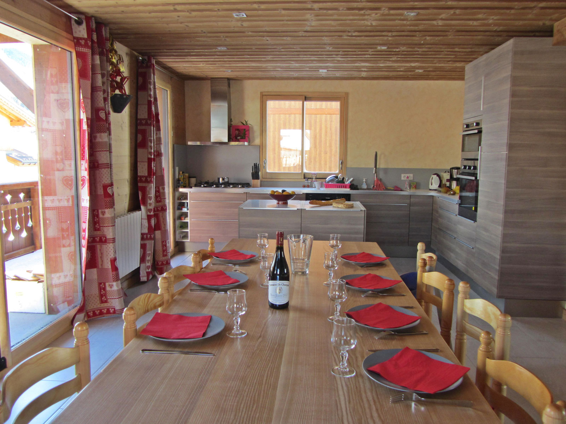 Roter Esstisch in einem Ferienhaus, zentrale Tischposition, ein Gedeck fehlt- vorher