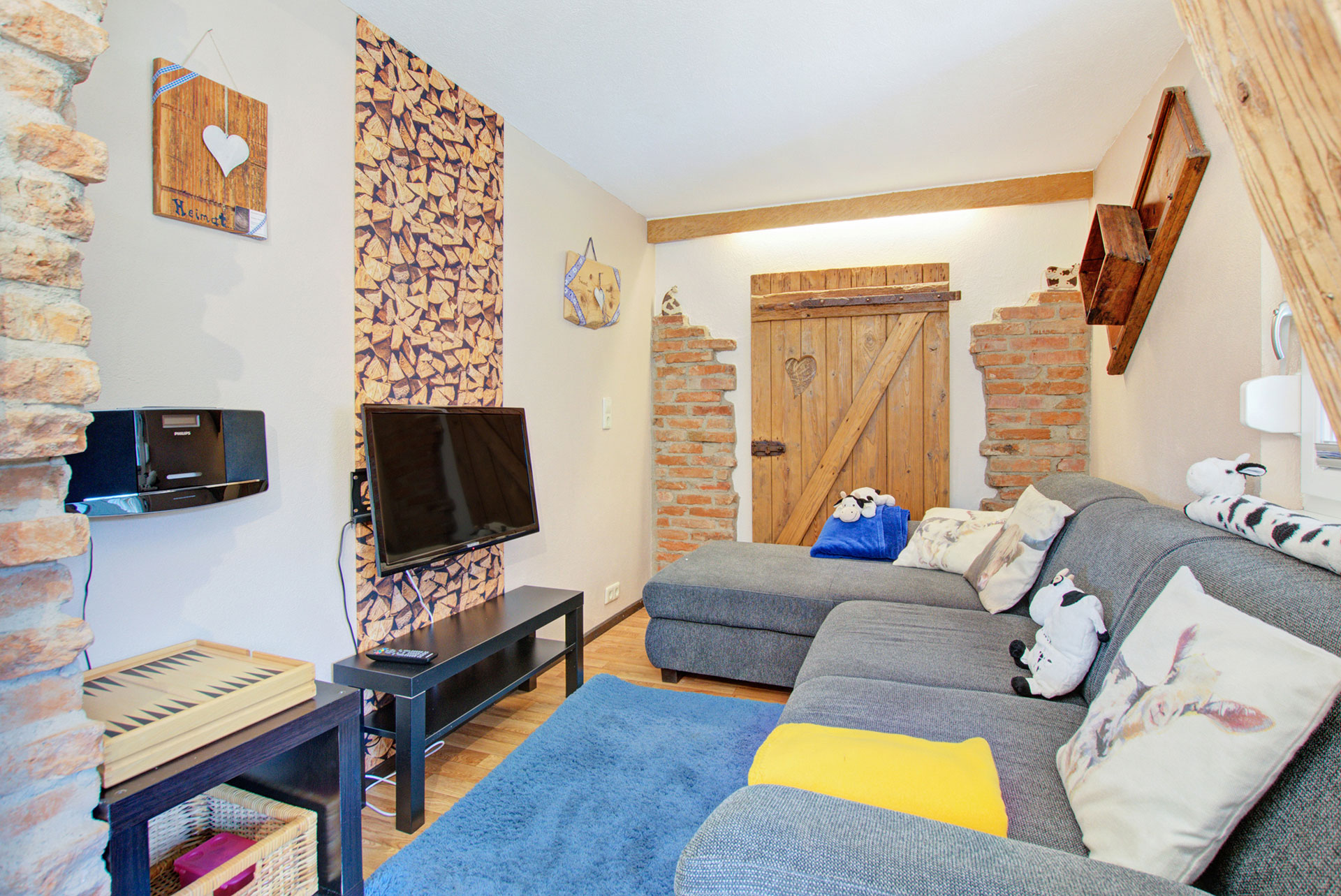 wohnzimmer mit grauer sofalandschaft und tv von Ferienwohnung