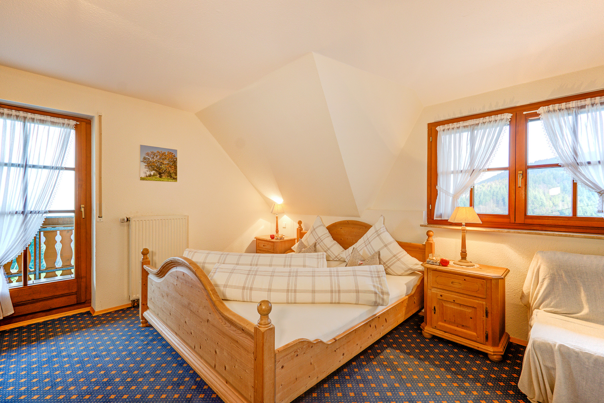 Hölzernes doppelbett mit nachttischlampe und fenster in ferienwohnung
