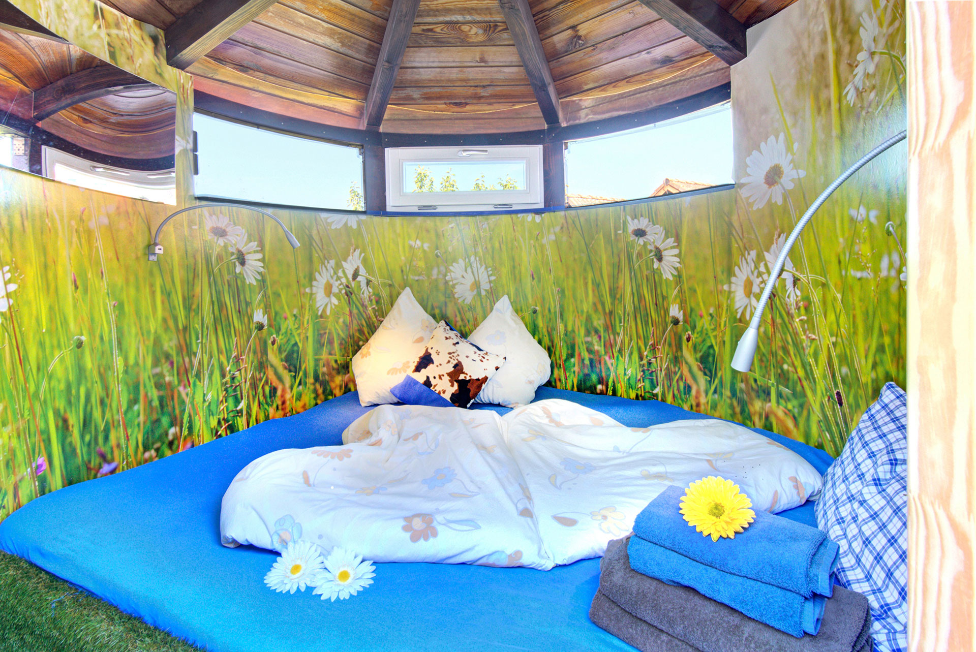 schlafzimmer mit herzbettwäsche und vielen blumen an der wand im früheren silo