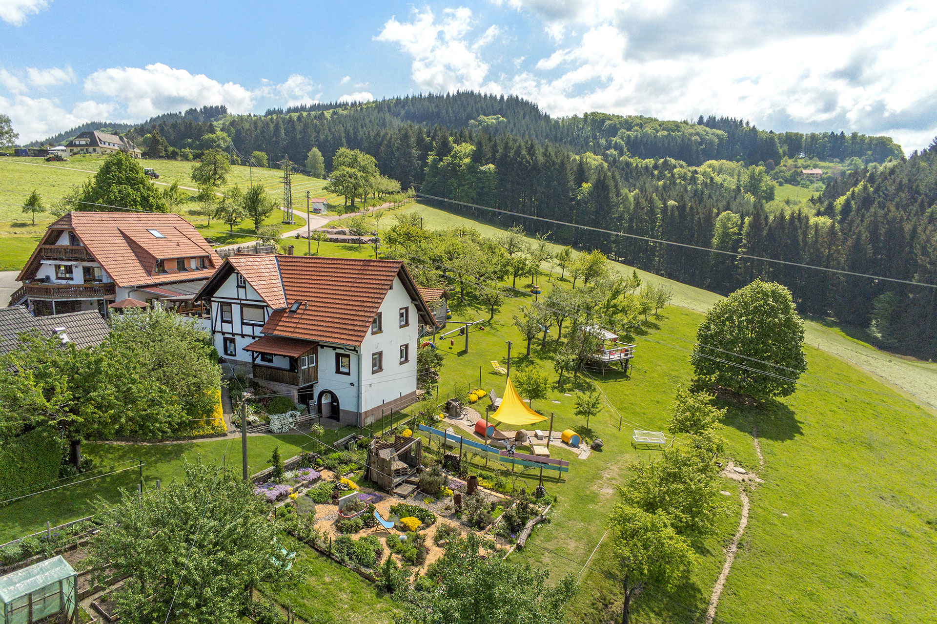 blick auf den ferienhof mit ferienhaus und ferienwohnungen sowie gärten und spielplatz