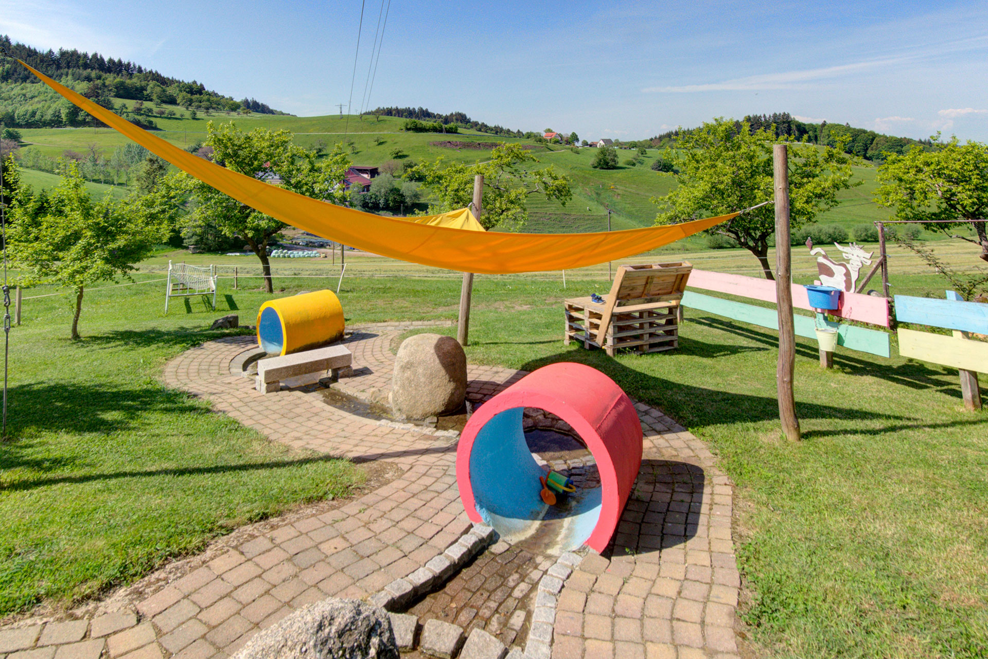 wasserspielplatz mit segel röhren und wasserlauf auf ferienhof