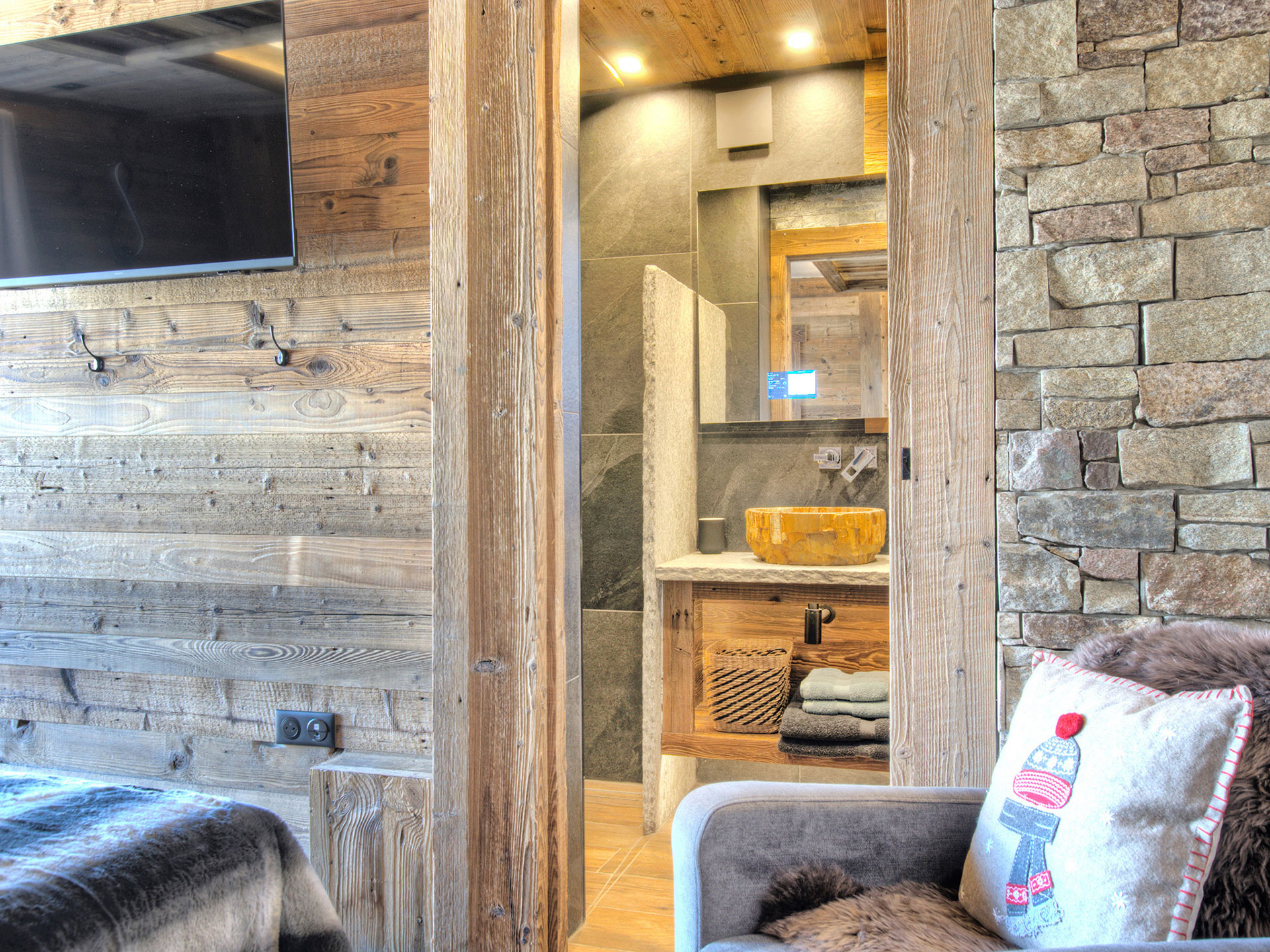 Blick aus Naturstein-Schlafzimmer zum hölzernen ensuite Badezimmer