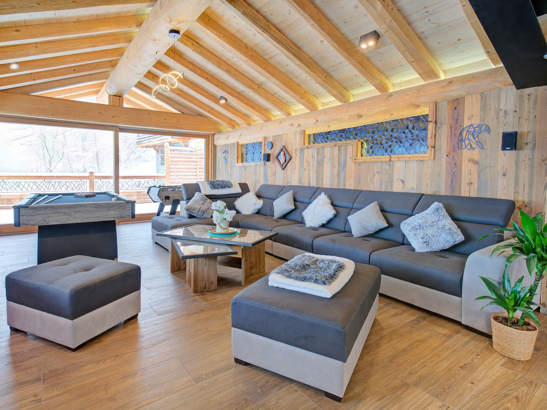 Gemütliches Wohnzimmer - Immobilienfoto im Luxus-Chalet mit Kamin und Schneebalkon