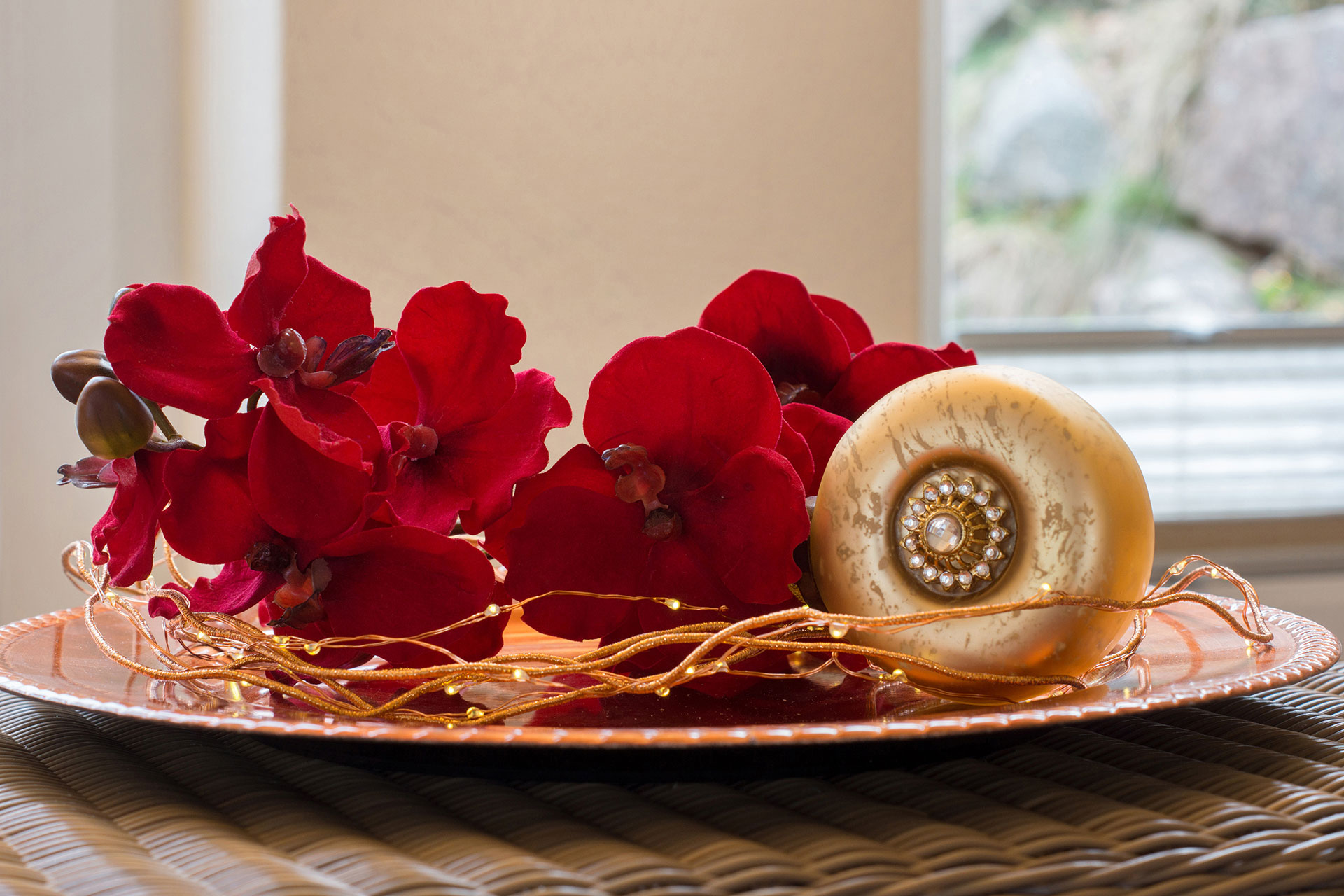 foto ferienwohnung wellnessbereich komposition auf teller aus roten orchideen und goldener kugel