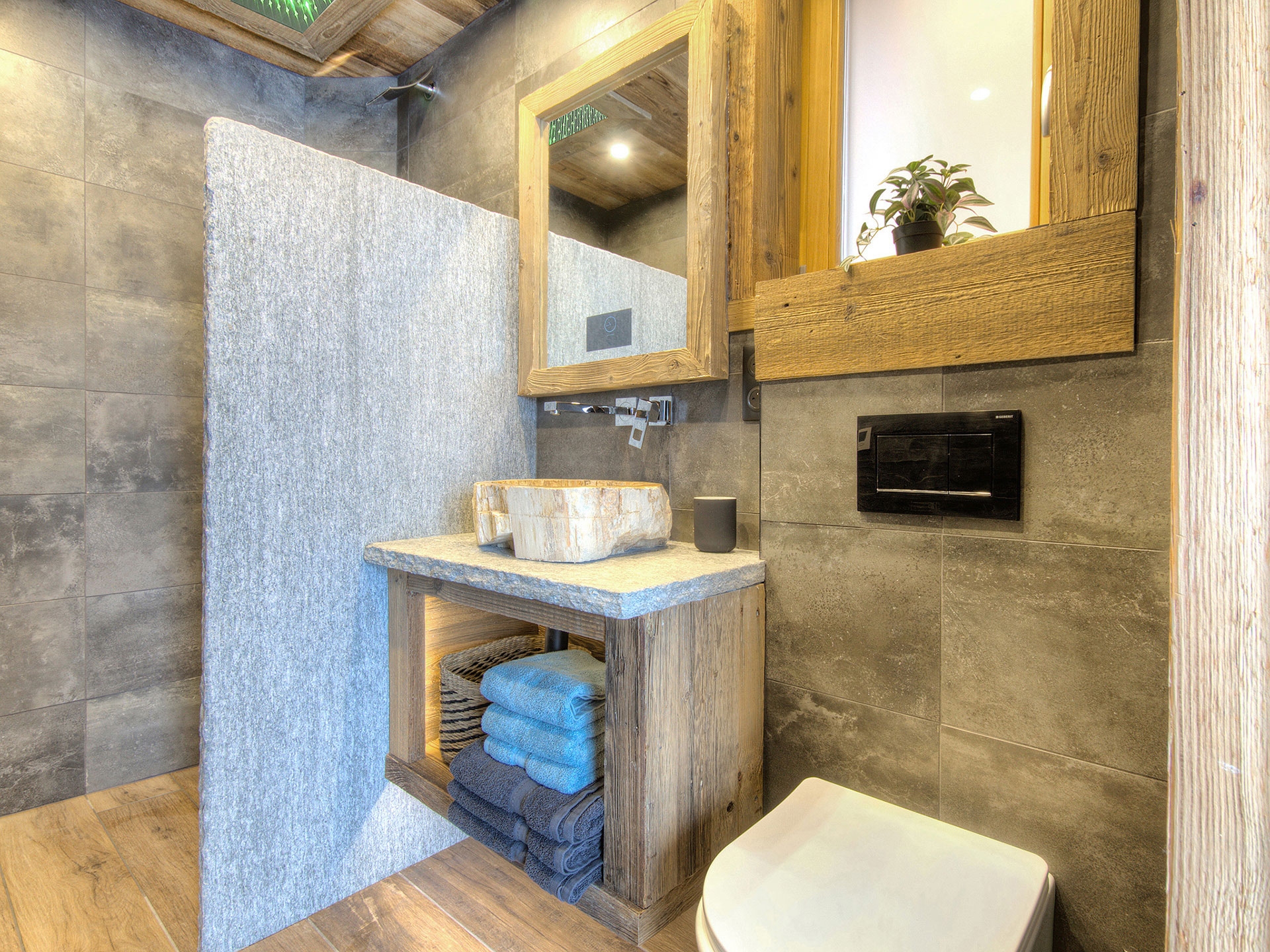 Kleines einladendes Badezimmer aus Naturstein mit Waschbecken Dusche und WC