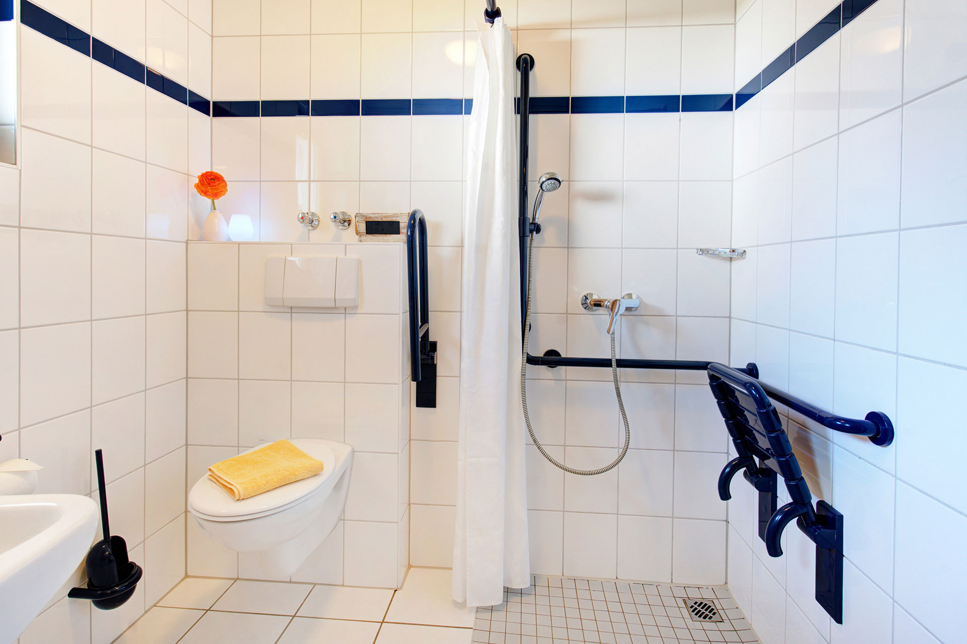 grosses badezimmer mit barrierefreier dusche uns Griffen am WC