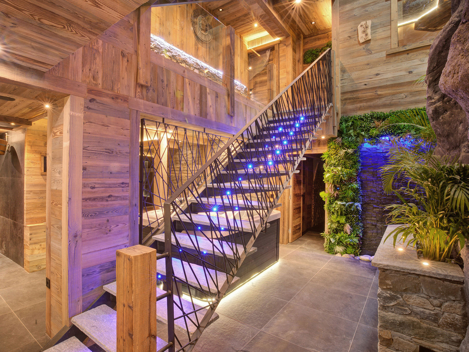 Treppe im Holzchalet mit blauer Beleuchtung am Abend