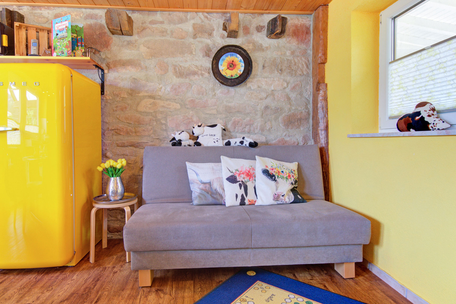 graues sofa mit kuhkissen in Ferienwohnung