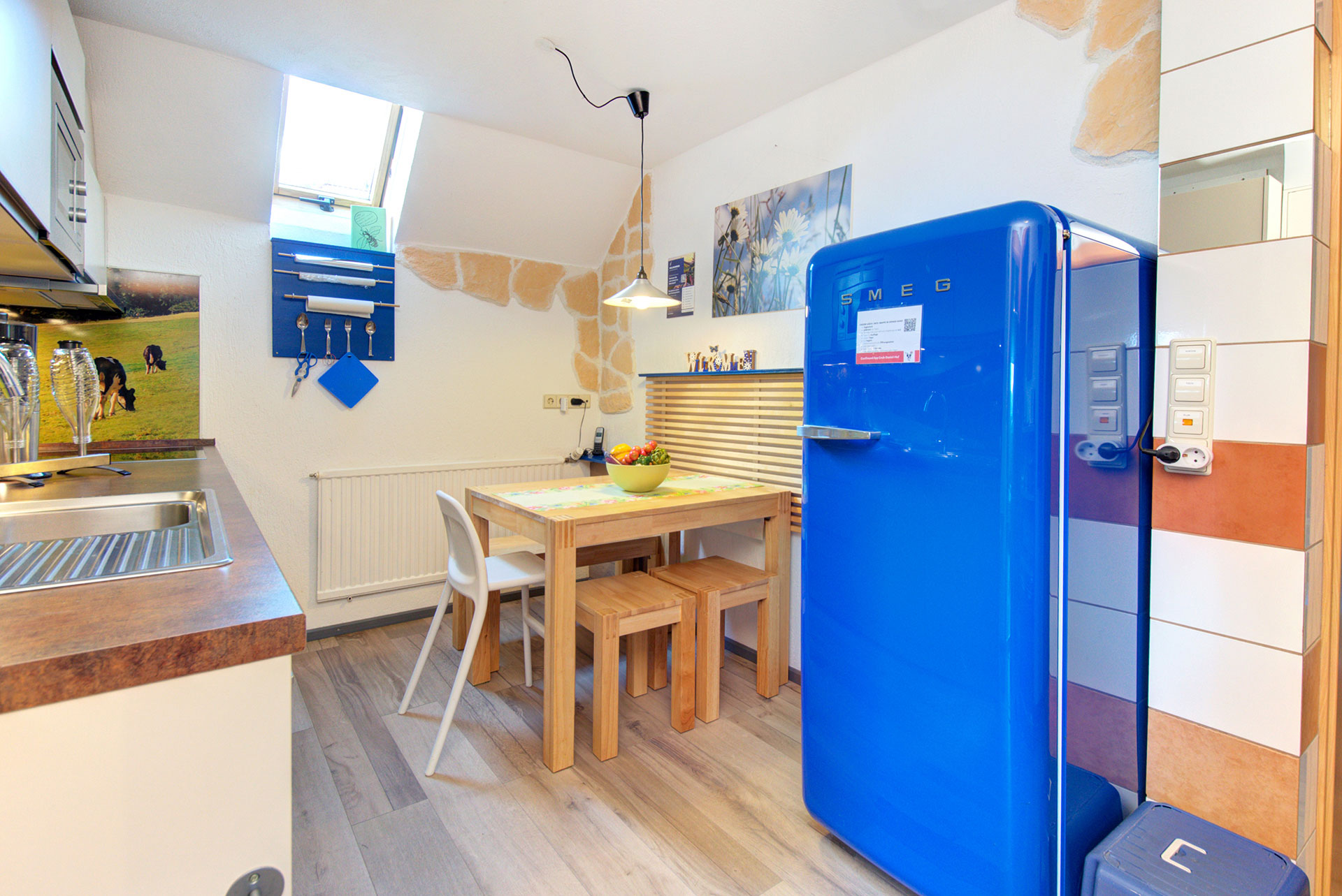 Essbereich mit kinderstuhl und grossem Kühlschrank in Ferienwohnung