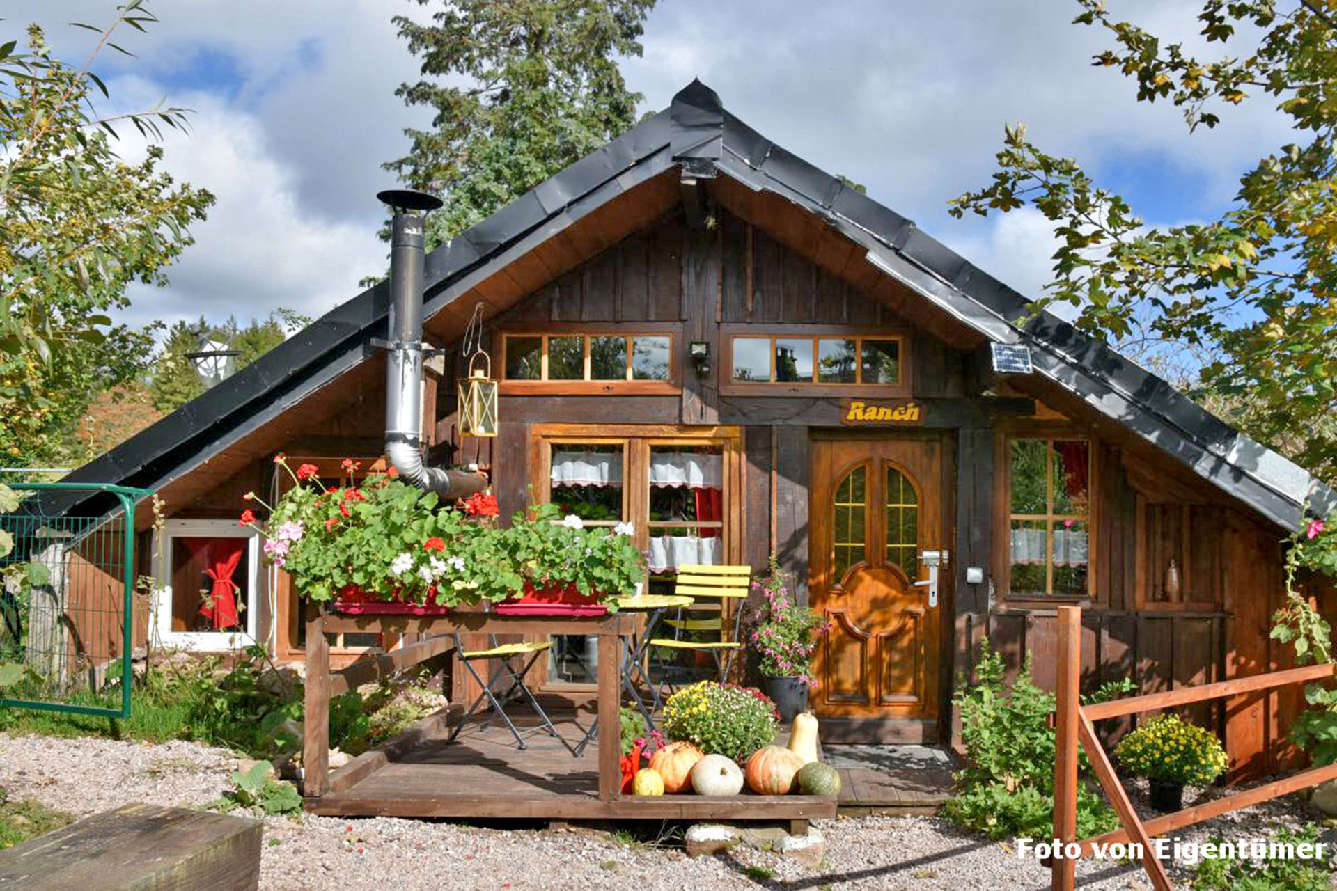 ferienhaus foto aussenaufnahme vom hoelzernen haeuschen mit blumenvorgarten