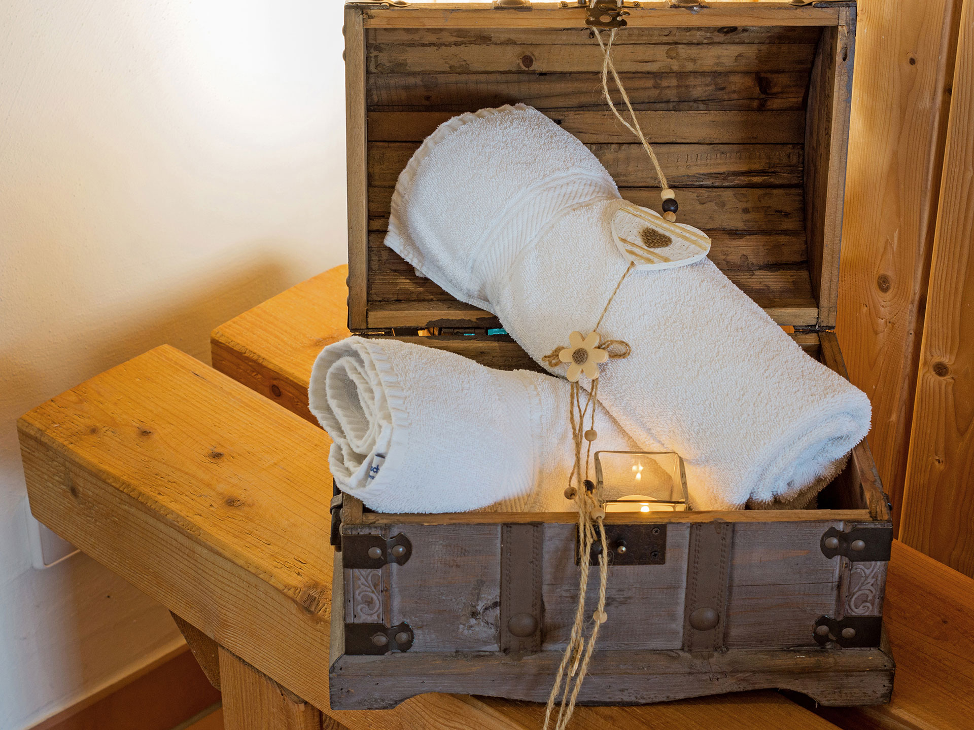 kleine holztruhe mit zwei handtüchern neben der Sauna