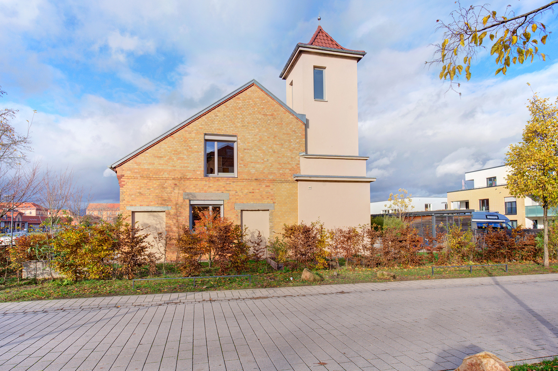 Verkaufsobjekt seitlich mit Turm und Vorgarten im Herbst