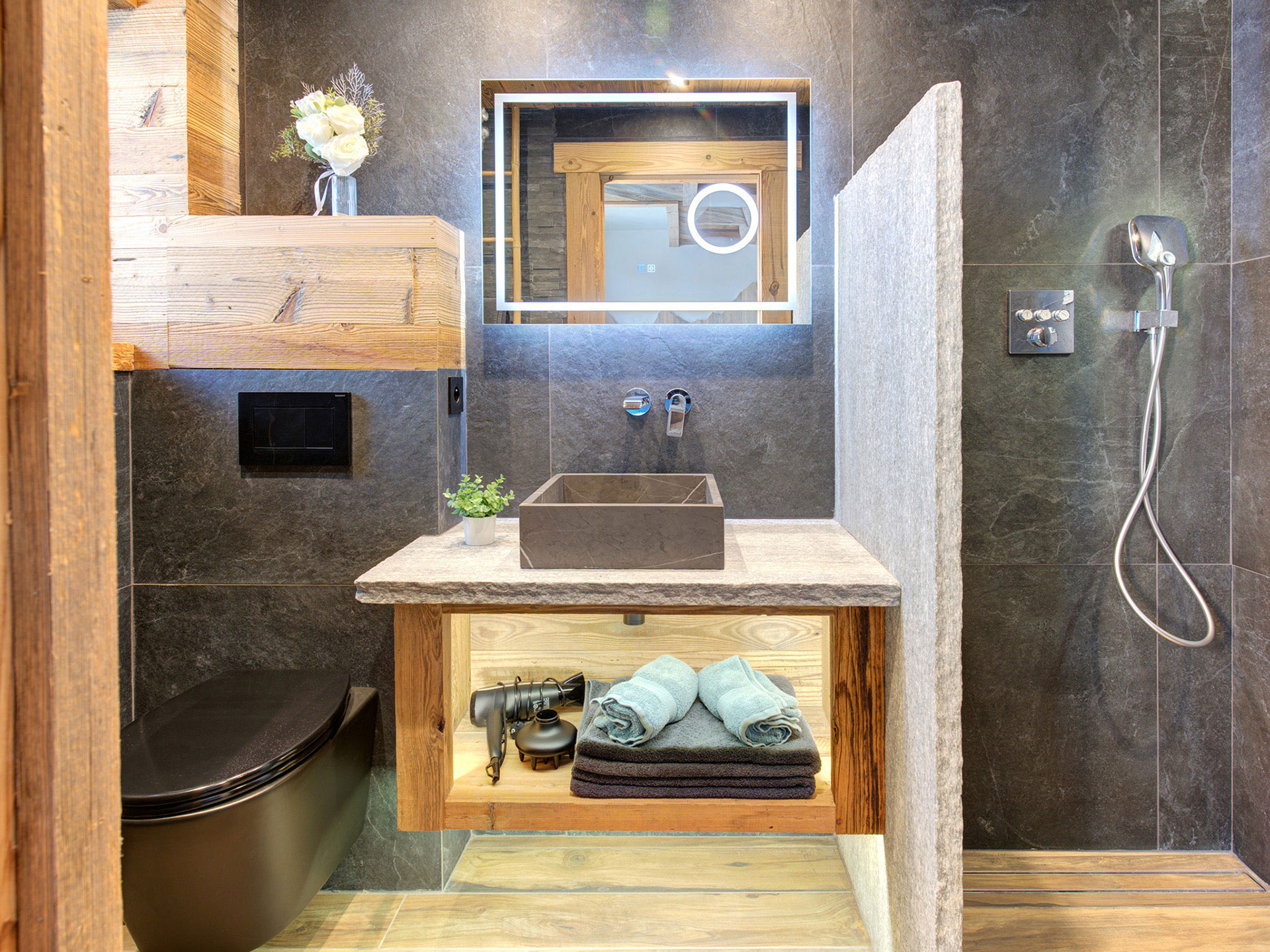 Badezimmer im Chalet mit Naturstein und Holz